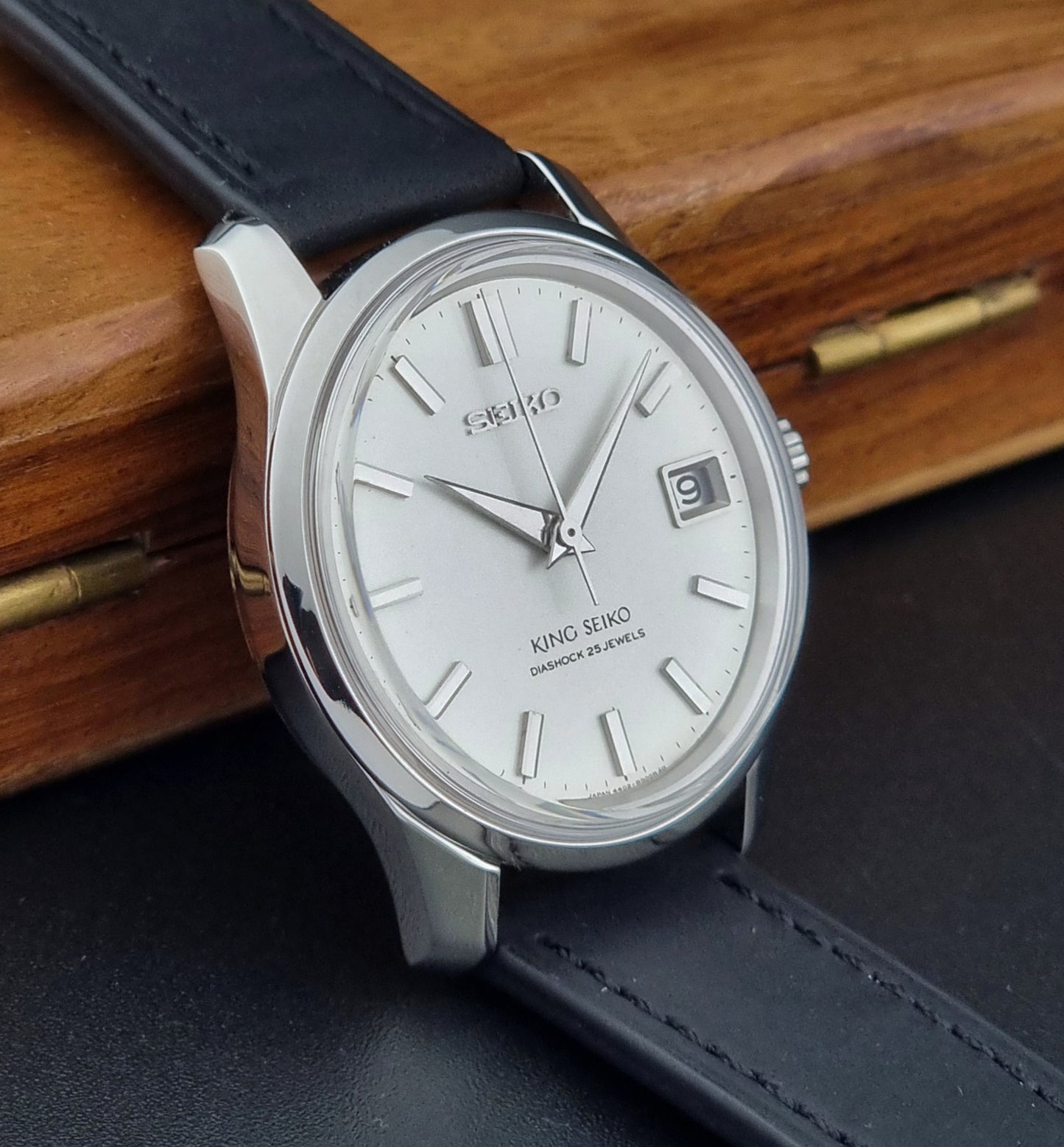 Vintage King Seiko 4402-8000 watch with black leather strap on a wooden surface