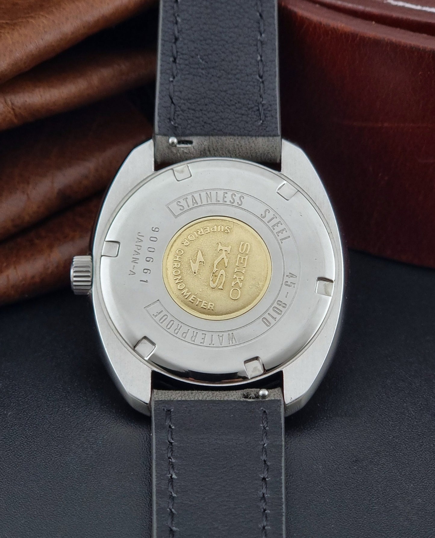 Vintage King Seiko 45-8010 Wristwatch with gray strap and silver case on a dark surface case back view