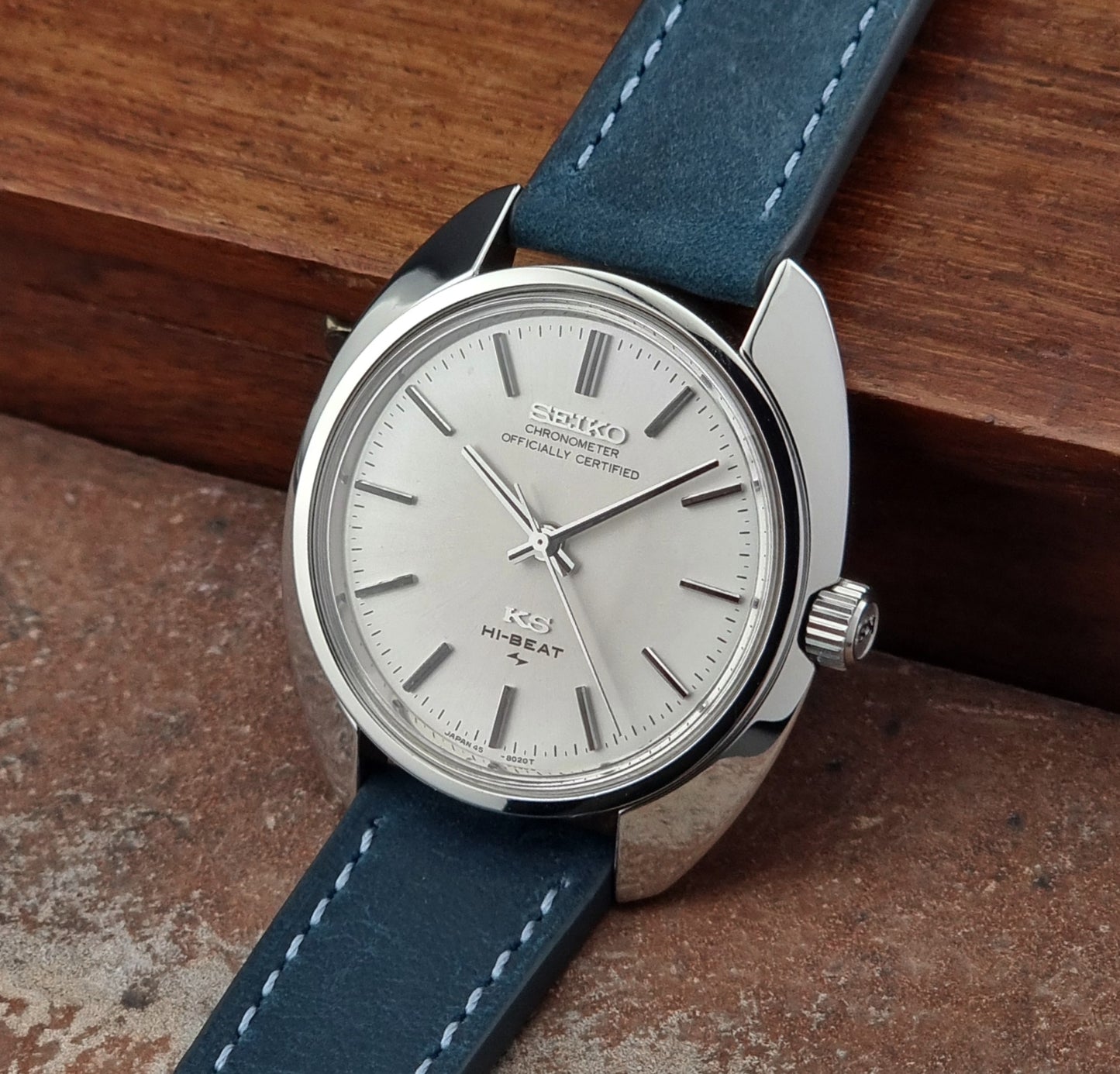 Vintage King Seiko Watch with blue strap and silver case on a wooden surface