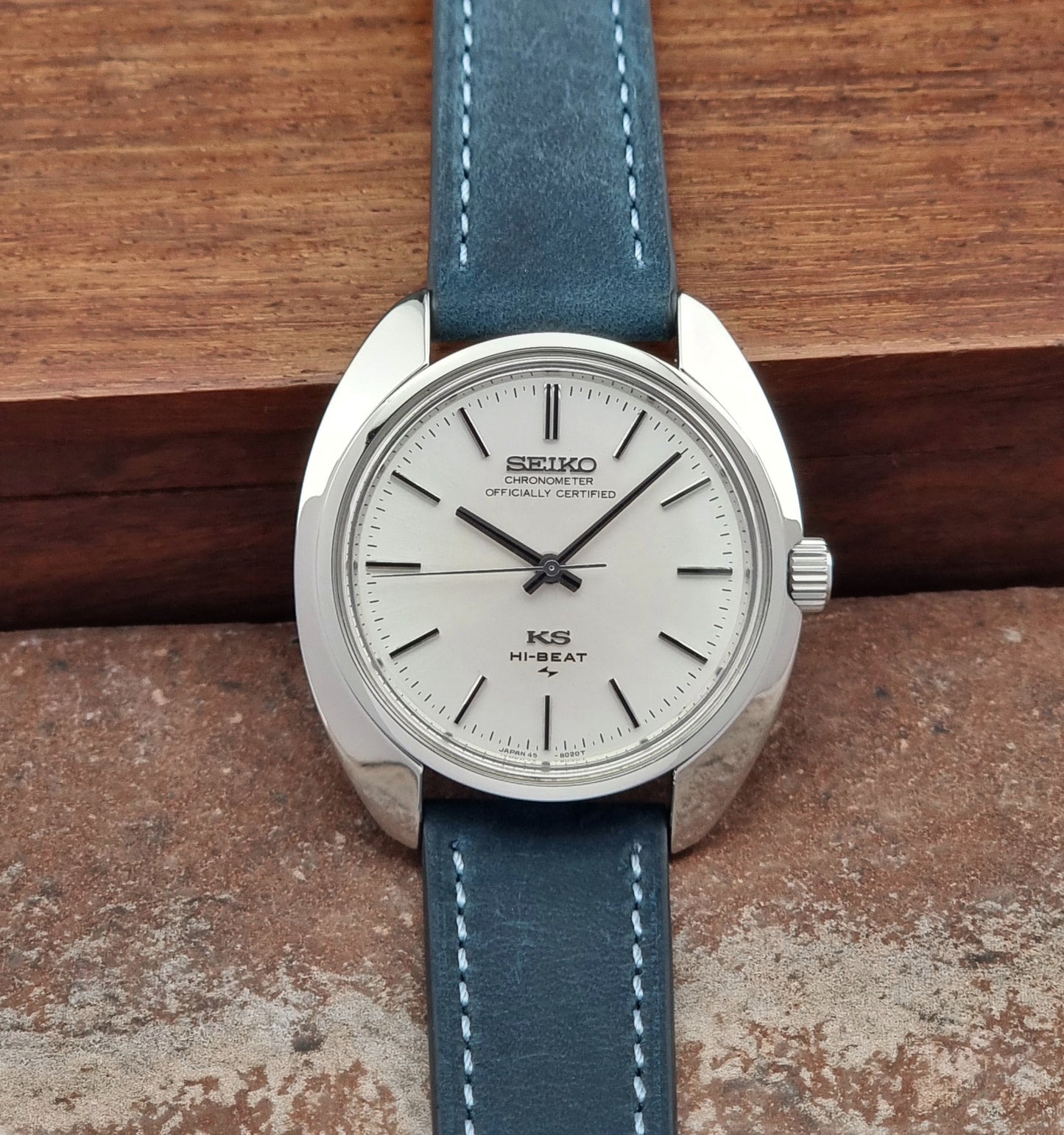 Vintage King Seiko watch with blue strap on a wooden surface