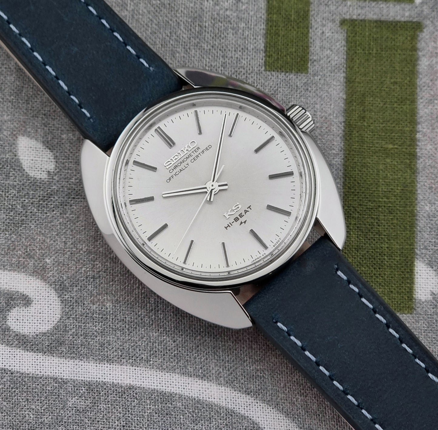 Vintage King Seiko Wristwatch with blue strap and silver case on a textured surface