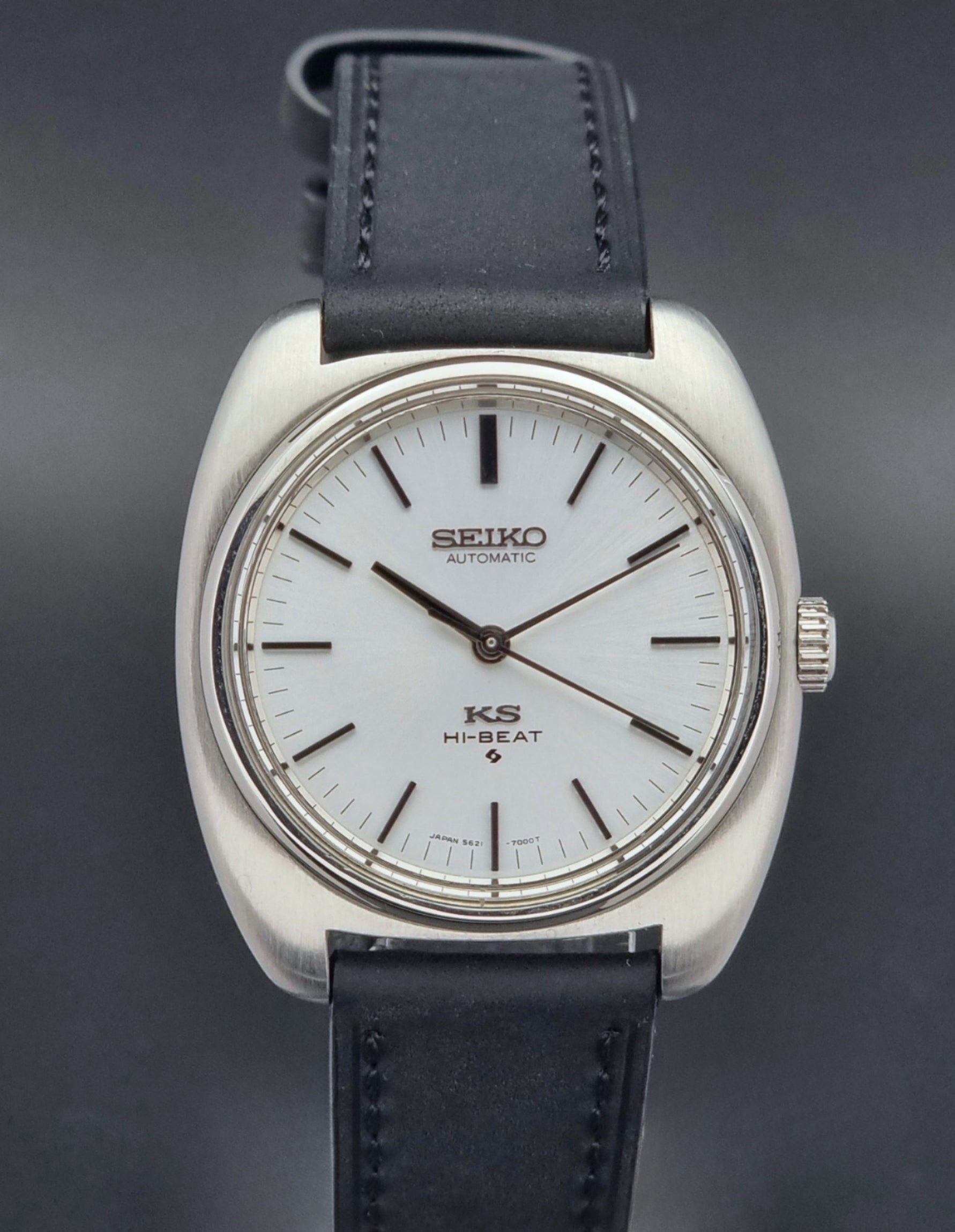 Vintage King Seiko 5621-700 Wristwatch with black leather strap on a dark surface close up