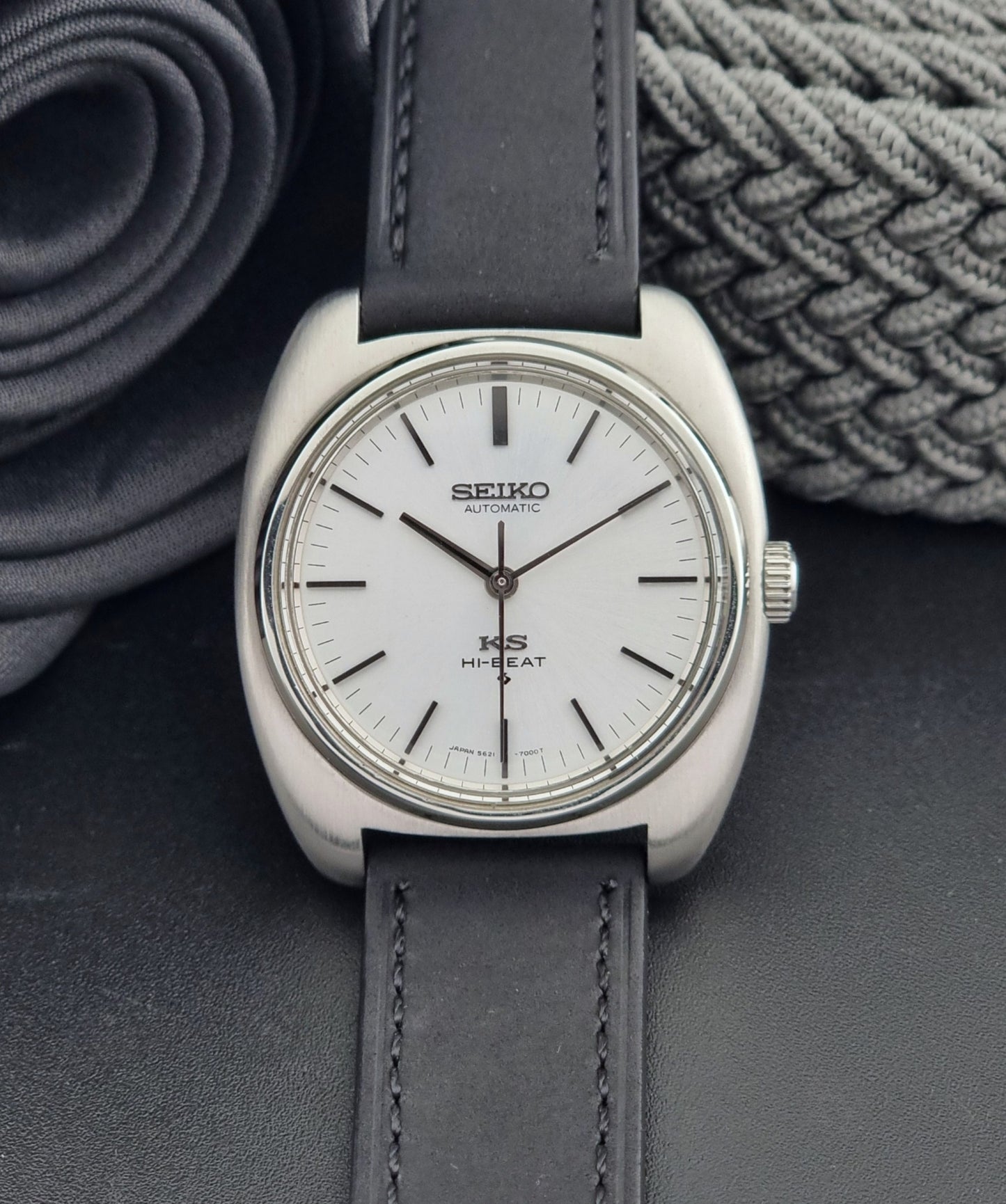 Vintage King Seiko 5621-700 Wristwatch with black leather strap on a dark surface front view