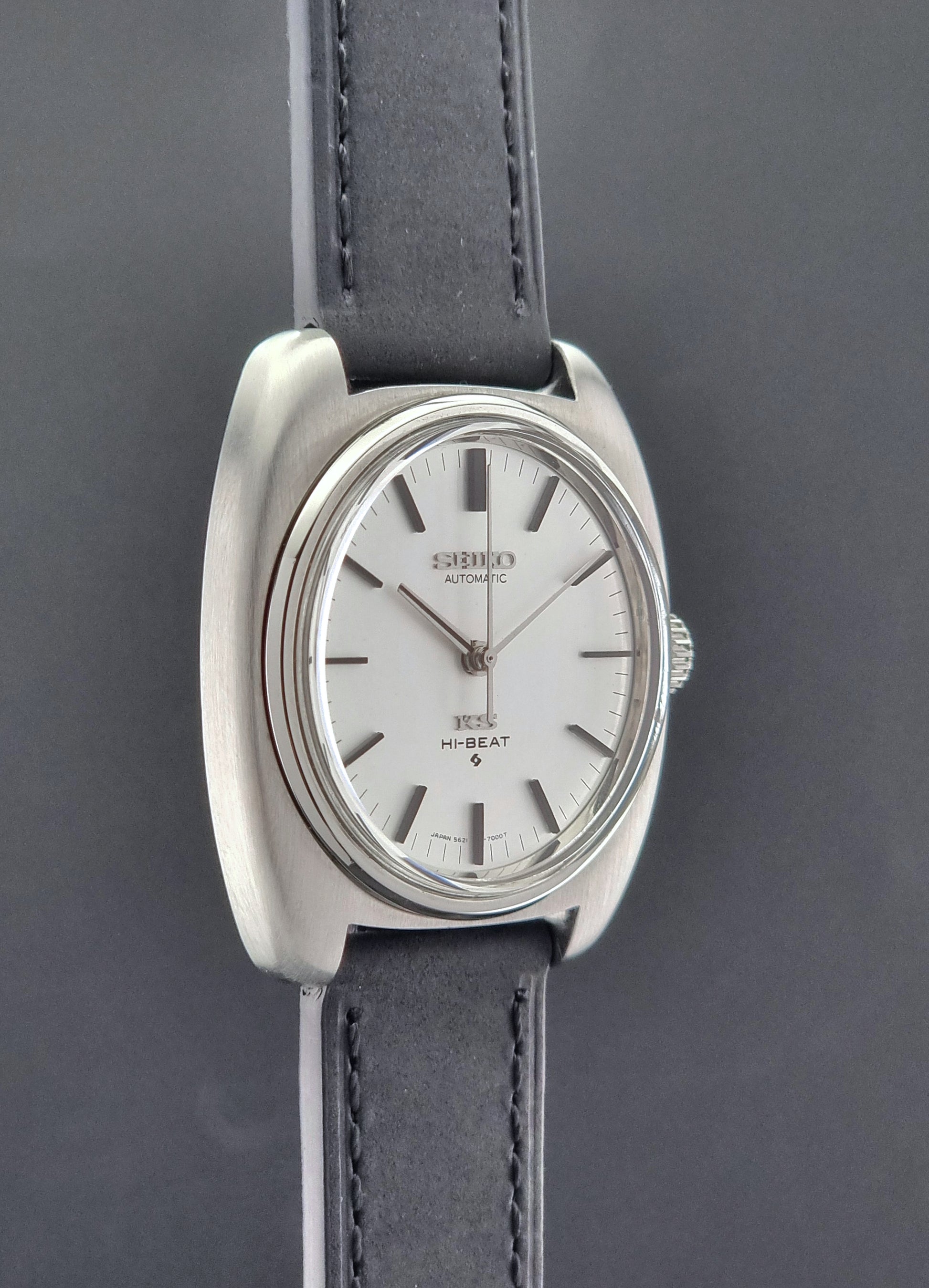 Vintage King Seiko 5621-700 Wristwatch with black leather strap on a dark surface side profile