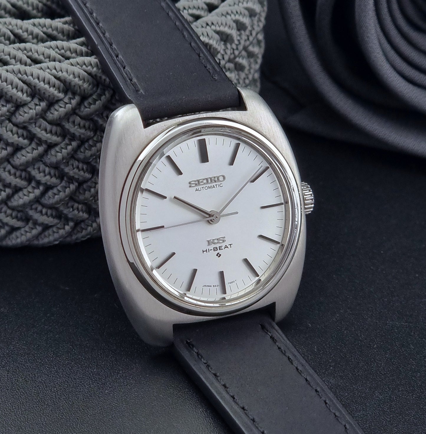Vintage King Seiko 5621-700 Wristwatch with black leather strap on a dark surface side view