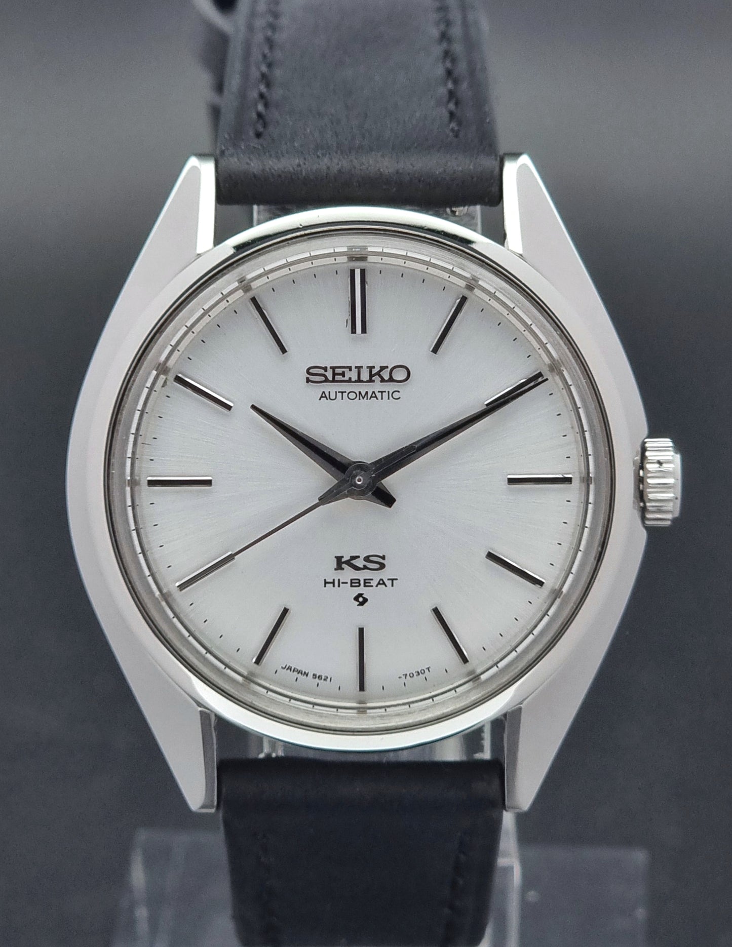 King Seiko watch with black leather strap on a reflective surface