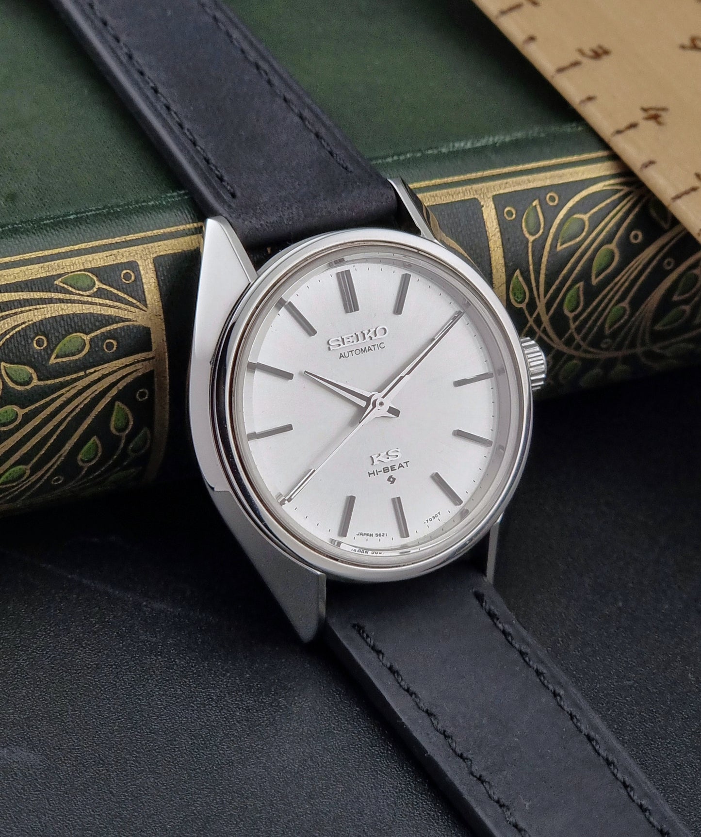 King Seiko watch with black leather strap on a textured surface