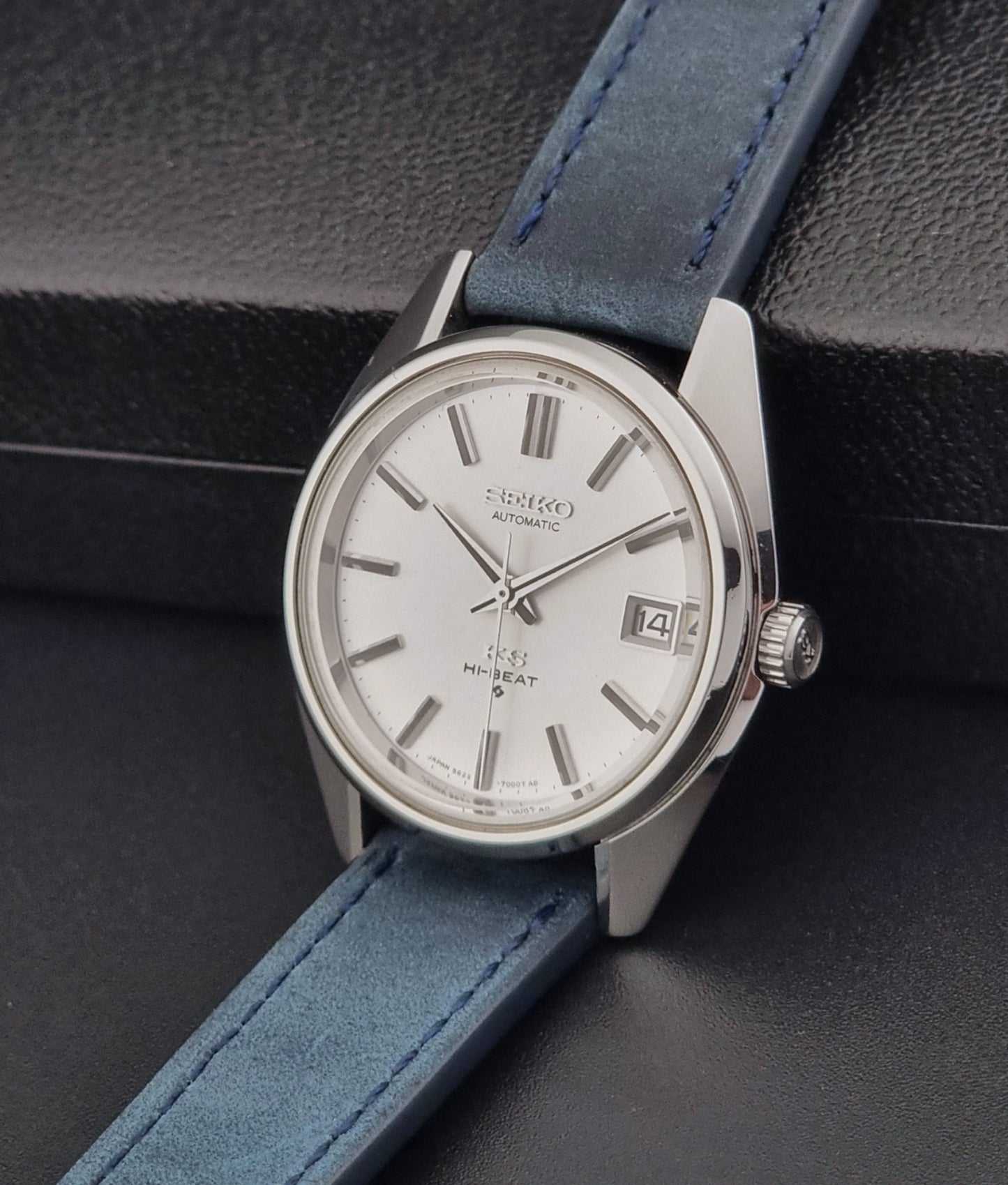 Vintage King Seiko 5625-7000 Wristwatch with blue strap and silver case on a dark textured background