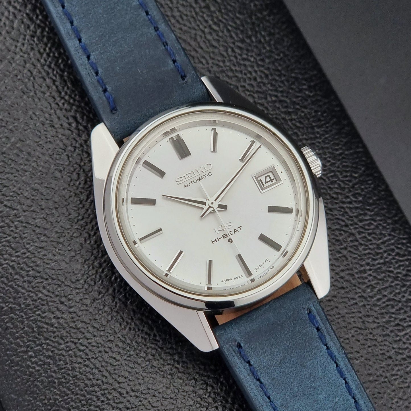Vintage King Seiko 5625-7000 Wristwatch with blue strap and silver case on a dark textured background