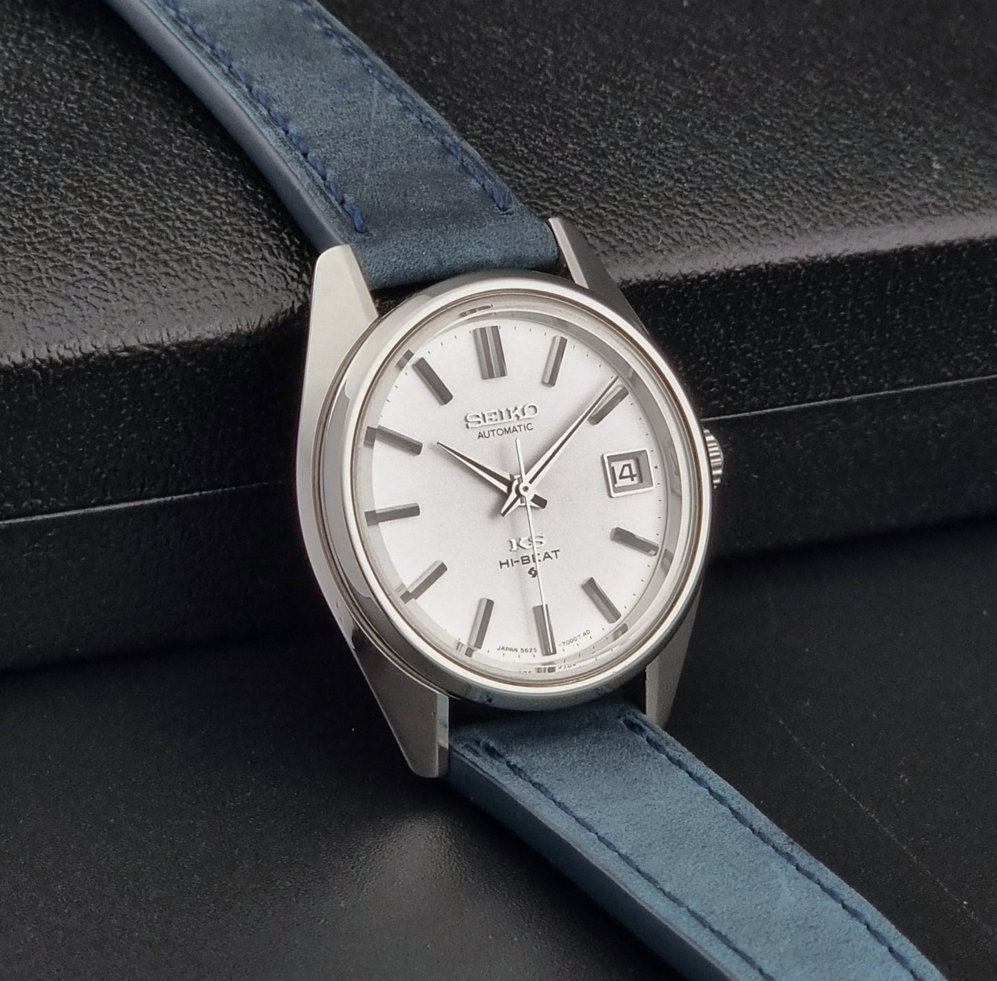 Vintage King Seiko 5625-7000 Wristwatch with blue strap and silver case on a dark textured background