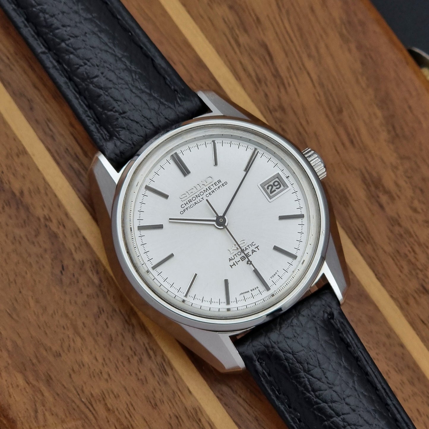 Vintage King Seiko 5625-7041 Wristwatch with black leather strap on a wooden surface close up dial