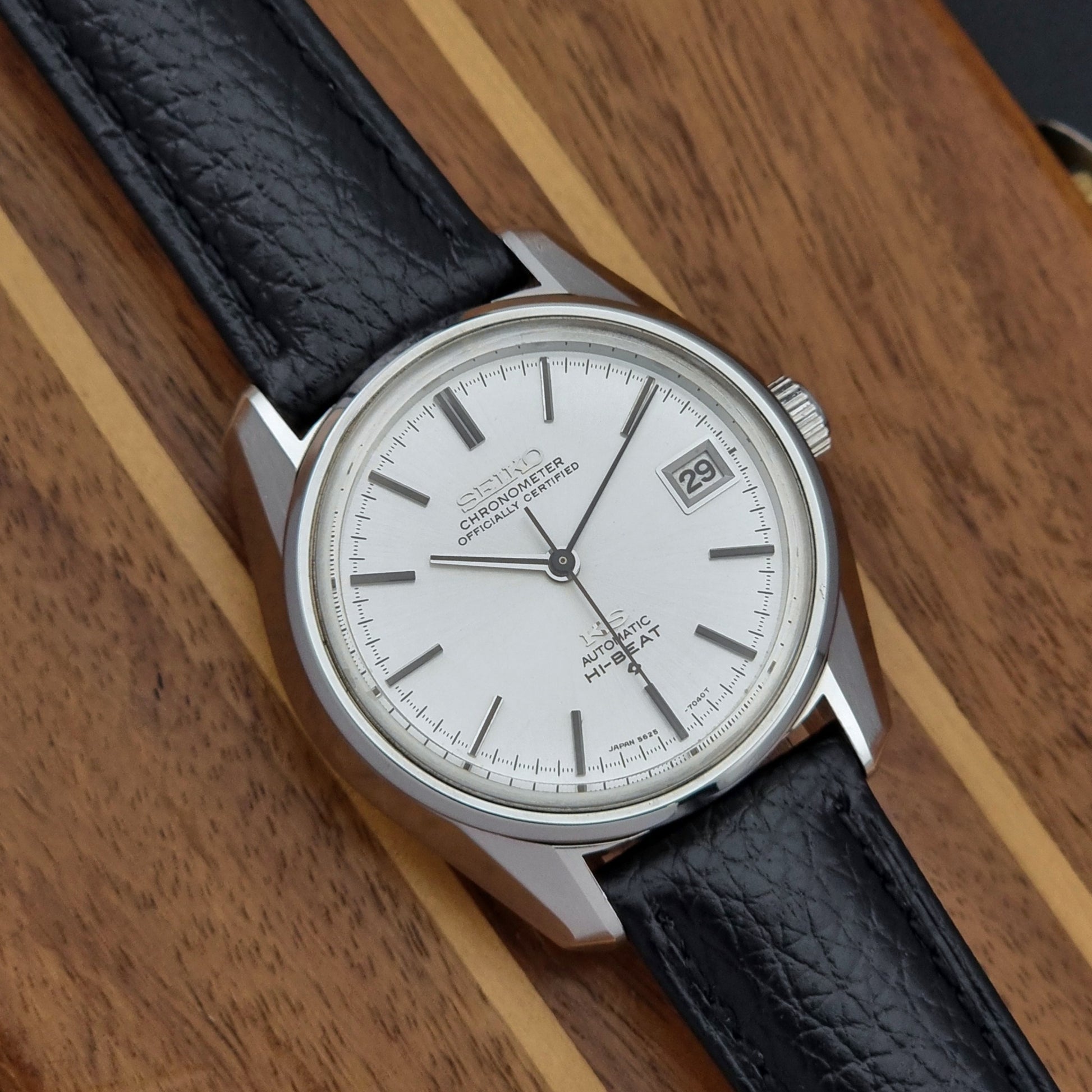 Vintage King Seiko 5625-7041 Wristwatch with black leather strap on a wooden surface close up dial