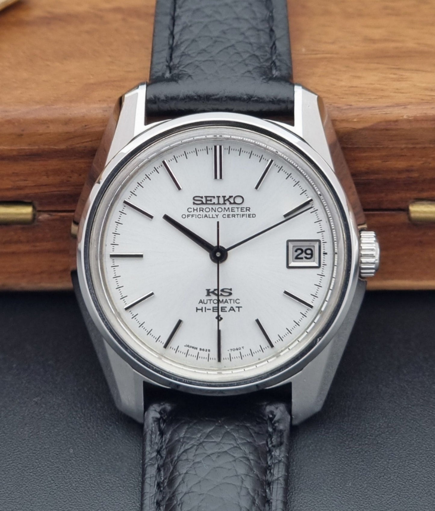 Vintage King Seiko 5625-7041 Wristwatch with black leather strap on a wooden surface close up dial view