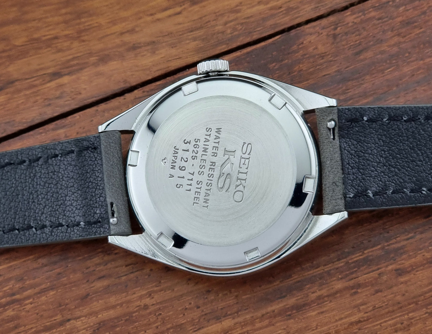 Back view of a King Seiko watch on a wooden surface