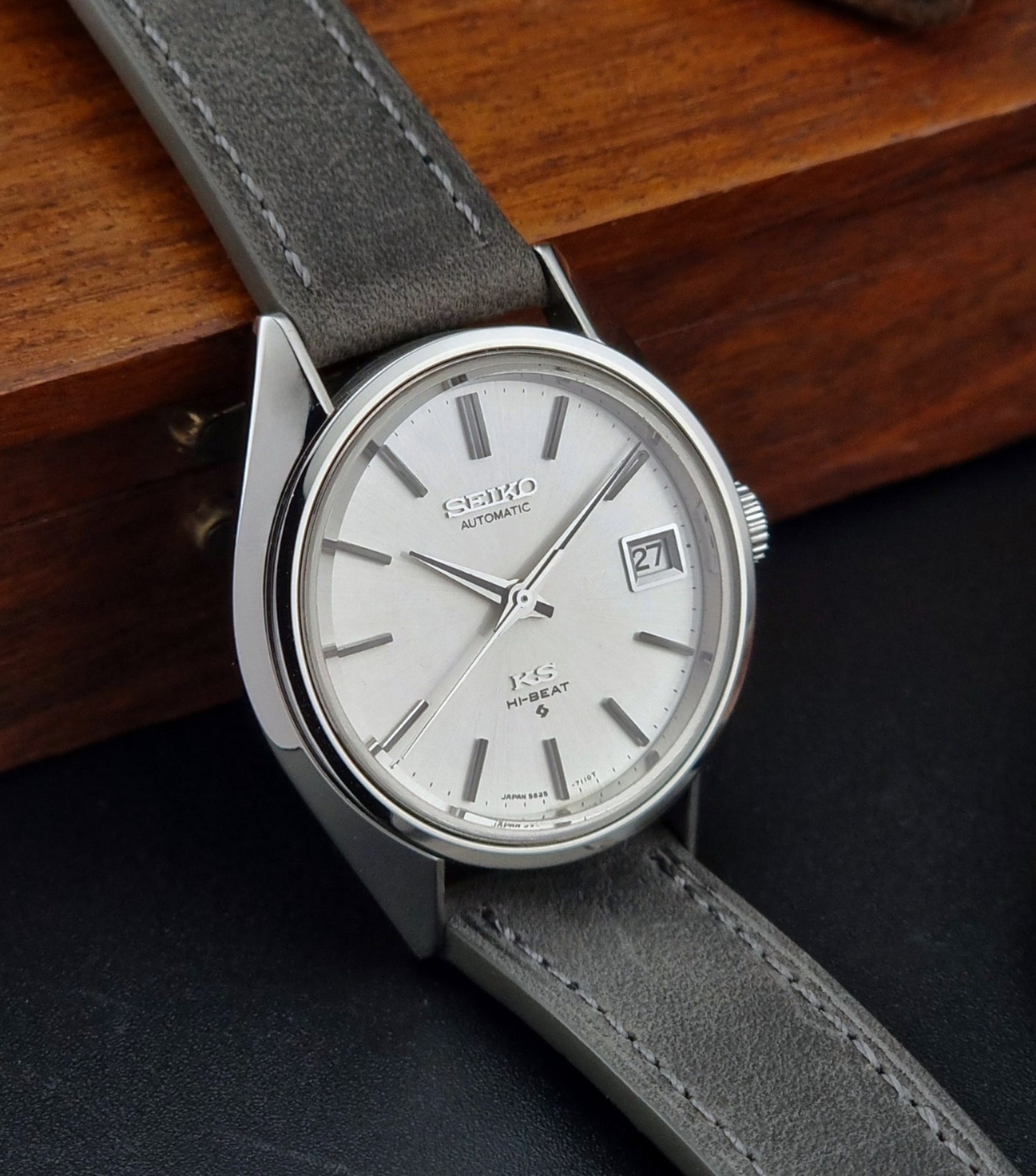 Vintage King Seiko watch with gray strap and silver case on a wooden surface