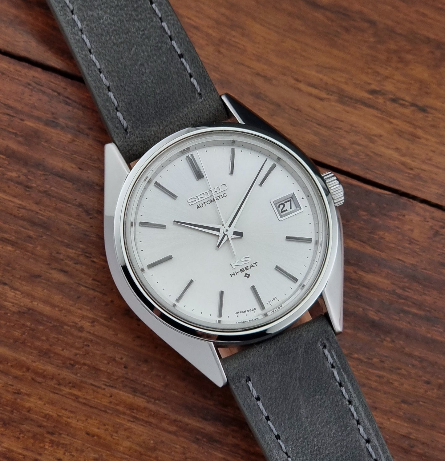 Vintage King Seiko watch with gray strap and silver case on wooden surface