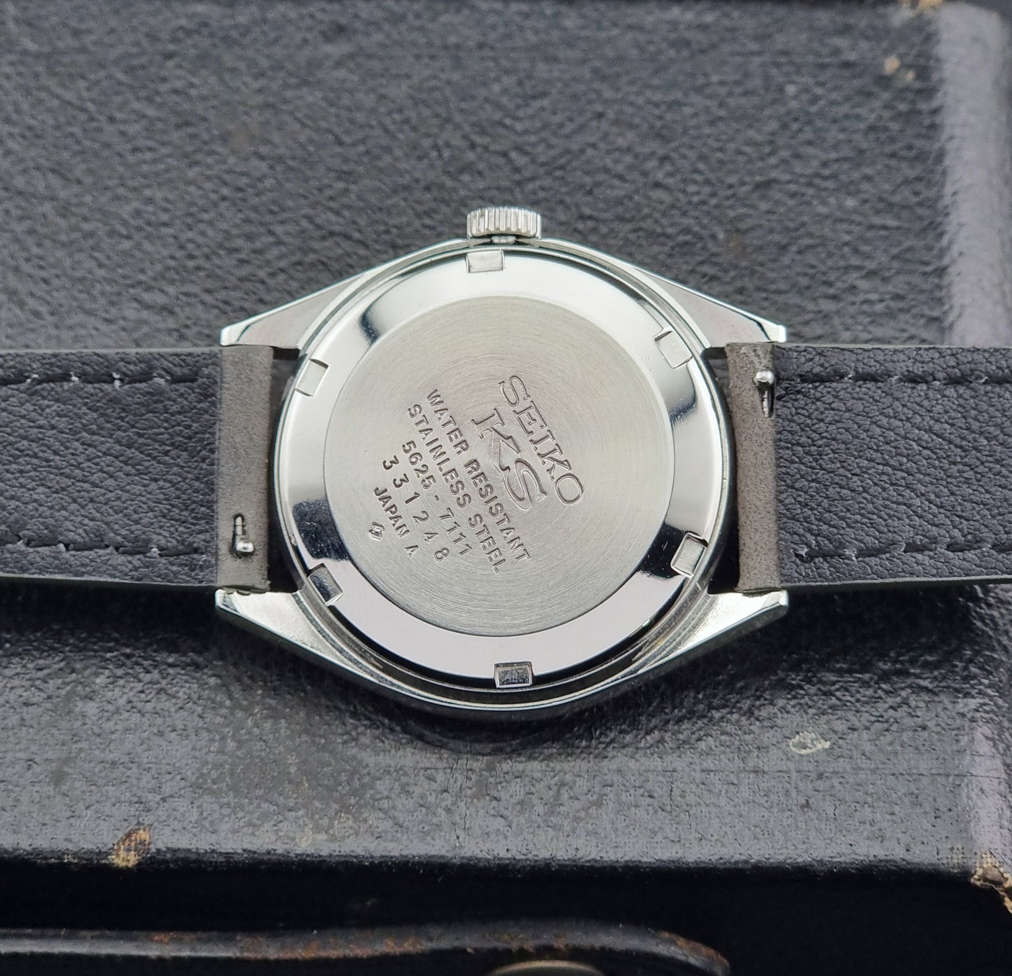 Back view of a Vintage King Seiko Wristwatch 5625-7111 on a grey leather strap