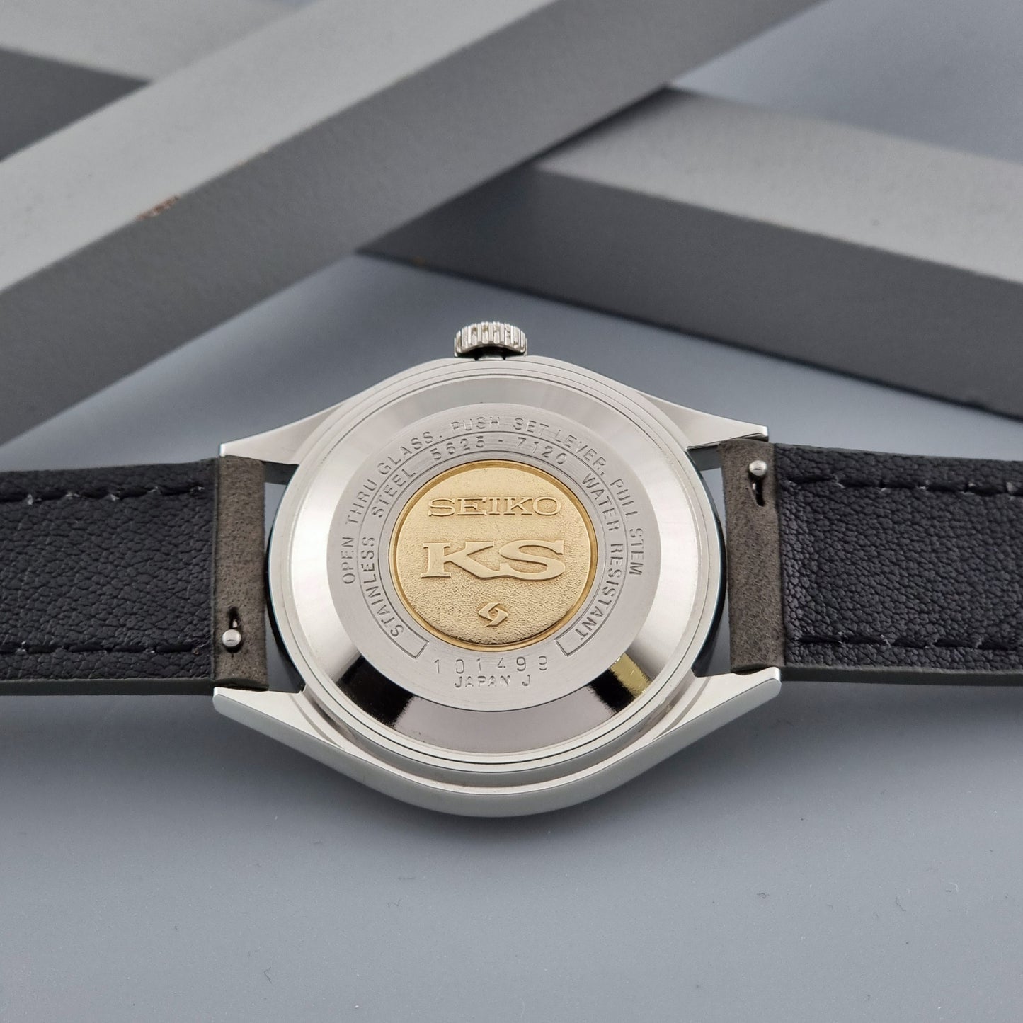 Vintage King Seiko watch 5625-7120 with a grey leather strap on a grey background case back view
