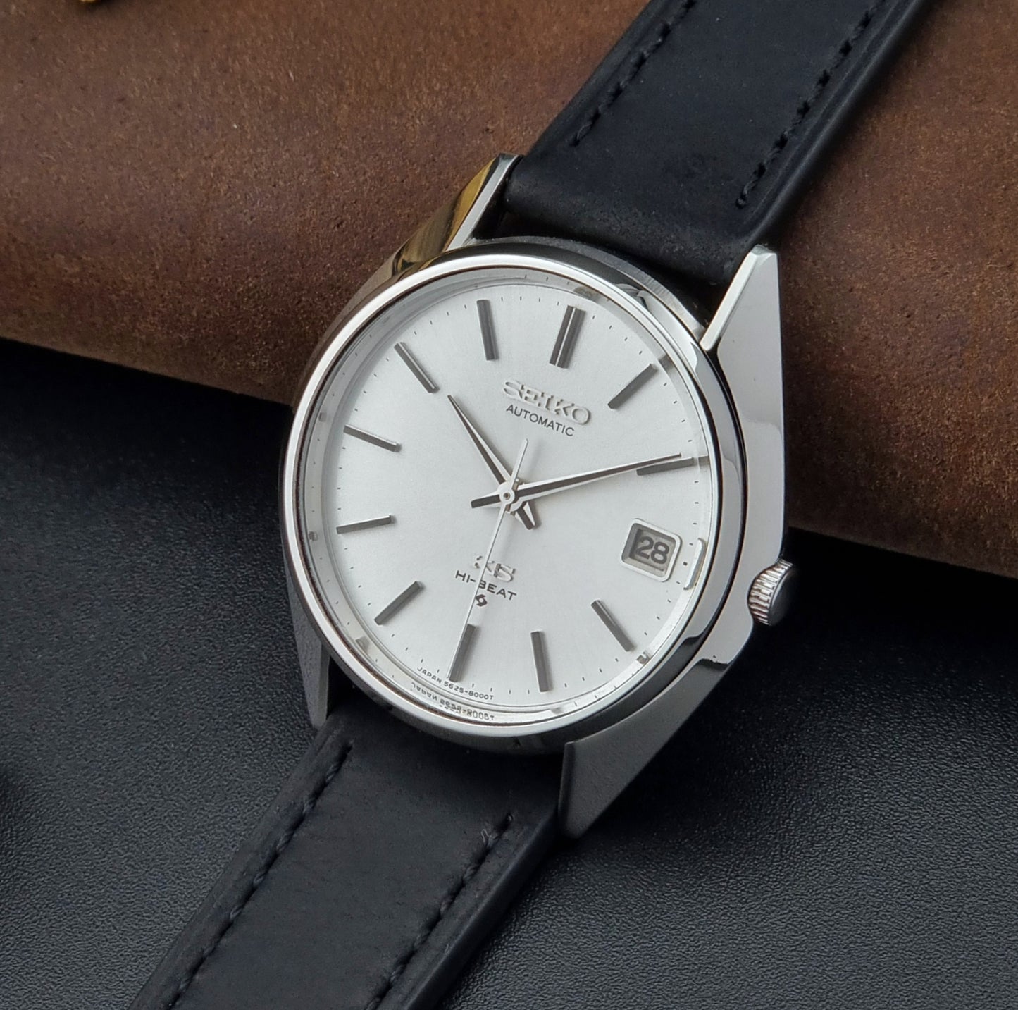 Vintage King Seiko watch with black leather strap on a dark surface