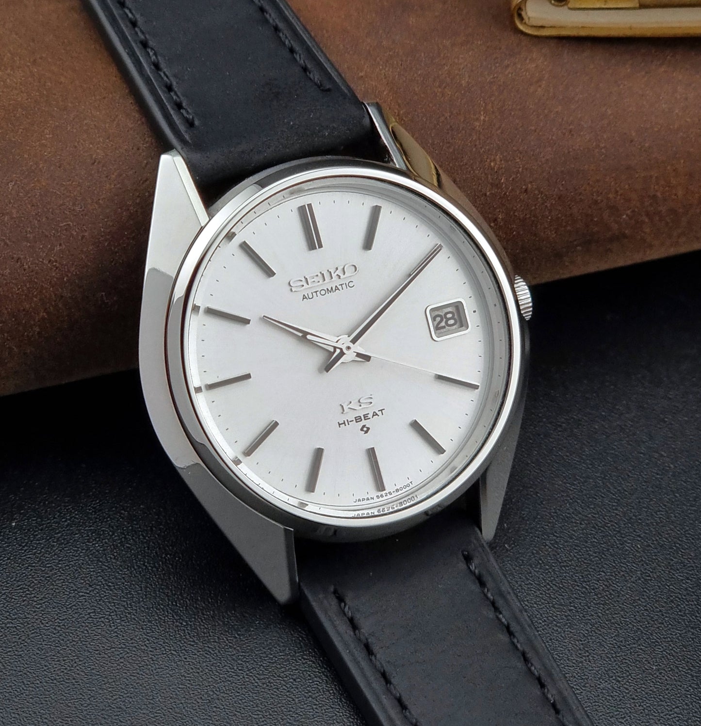Vintage King Seiko watch with black leather strap on a dark surface