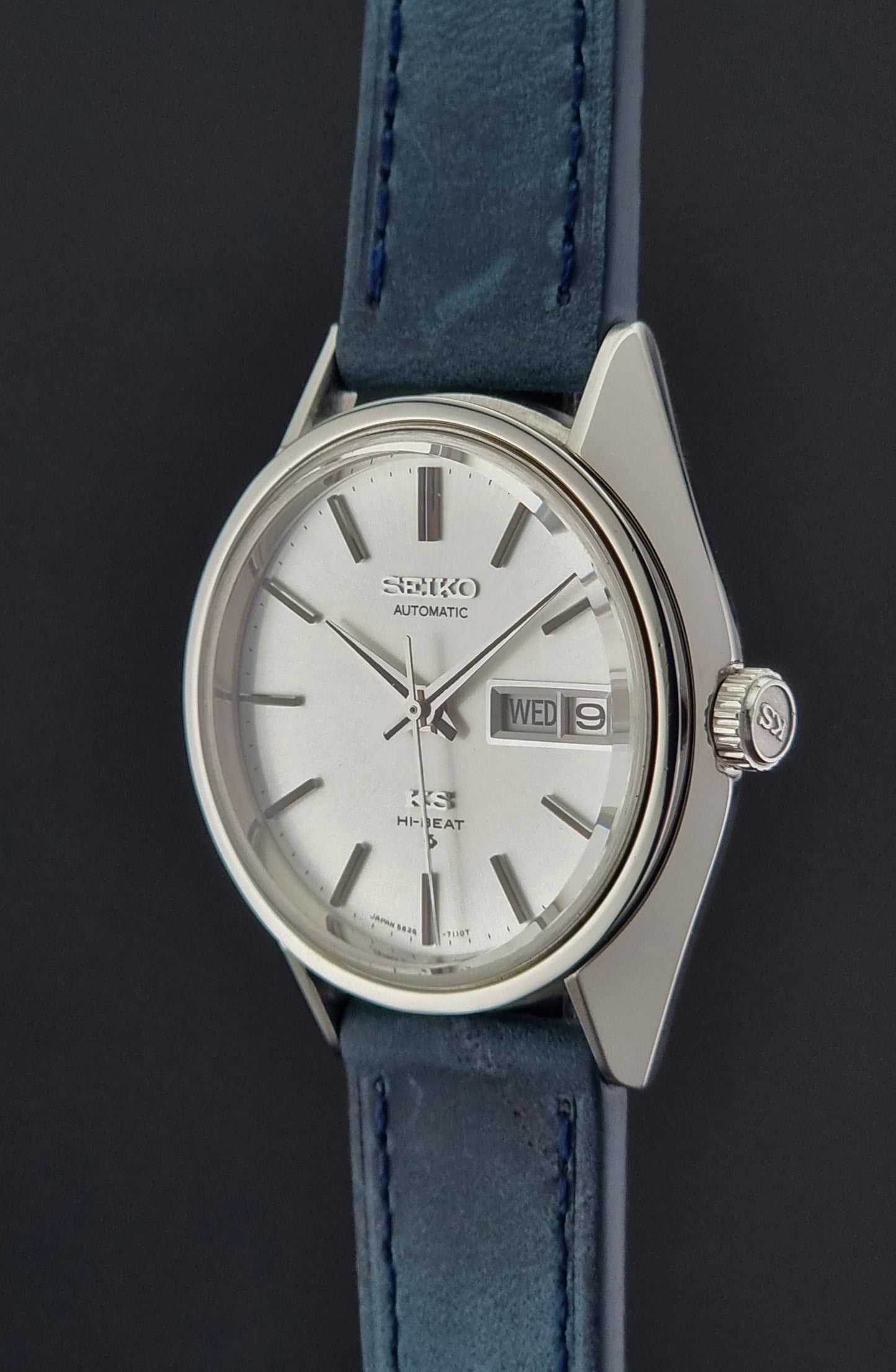 Vintage King Seiko 5626-7110 Wristwatch with blue strap and silver case on a dark textured background