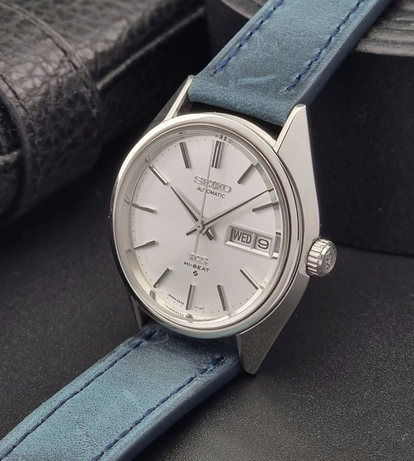 Vintage King Seiko 5626-7110 Wristwatch with blue strap and silver case on a dark textured background