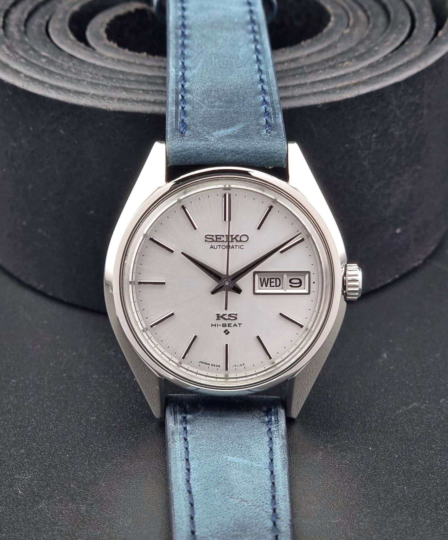 Vintage King Seiko 5626-7110 Wristwatch with blue strap and silver case on a dark textured background