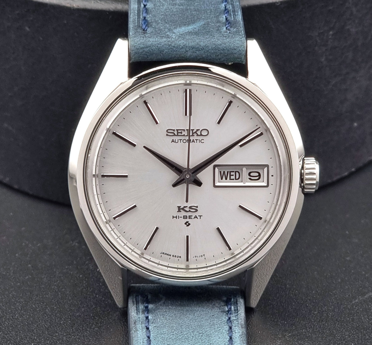 Vintage King Seiko 5626-7110 Wristwatch with blue strap and silver case on a dark textured background