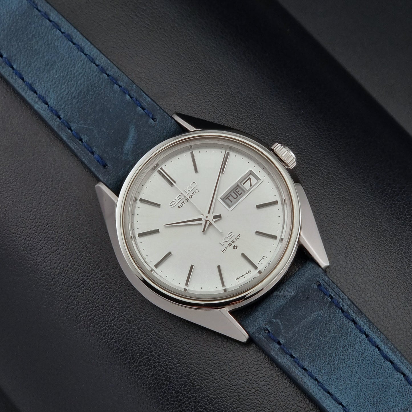 Vintage King Seiko 5626-7110 Wristwatch with blue strap and silver case on a dark textured background