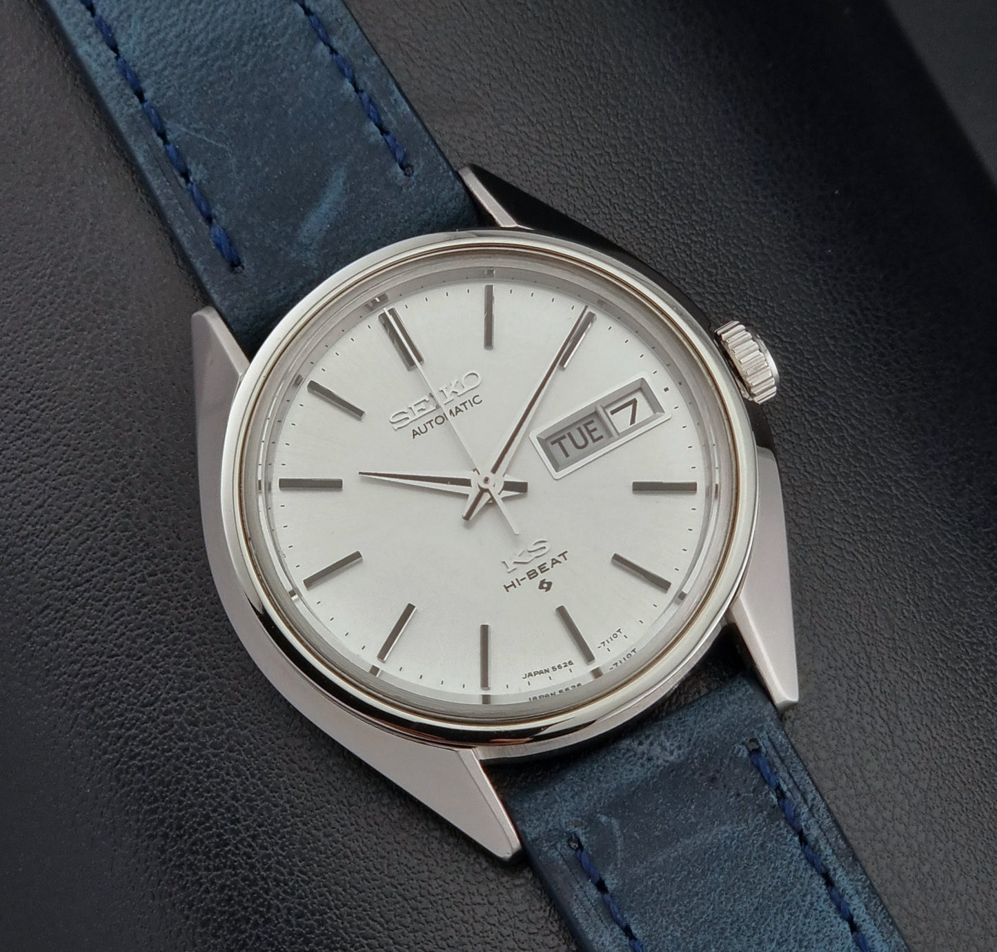 Vintage King Seiko 5626-7110 Wristwatch with blue strap and silver case on a dark textured background