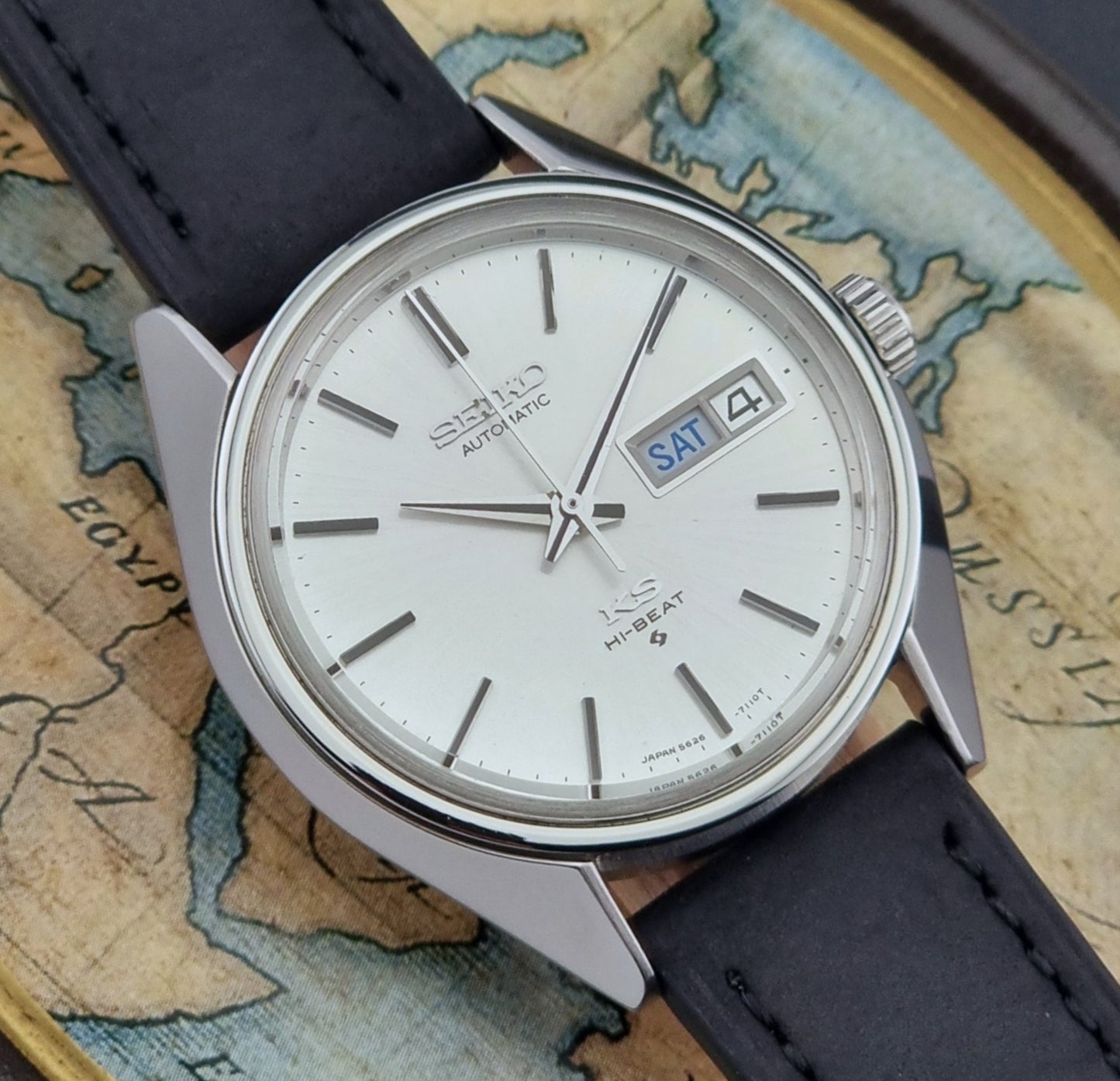 Vintage King Seiko Wristwatch 5626-7110 on a black strap on a world map background