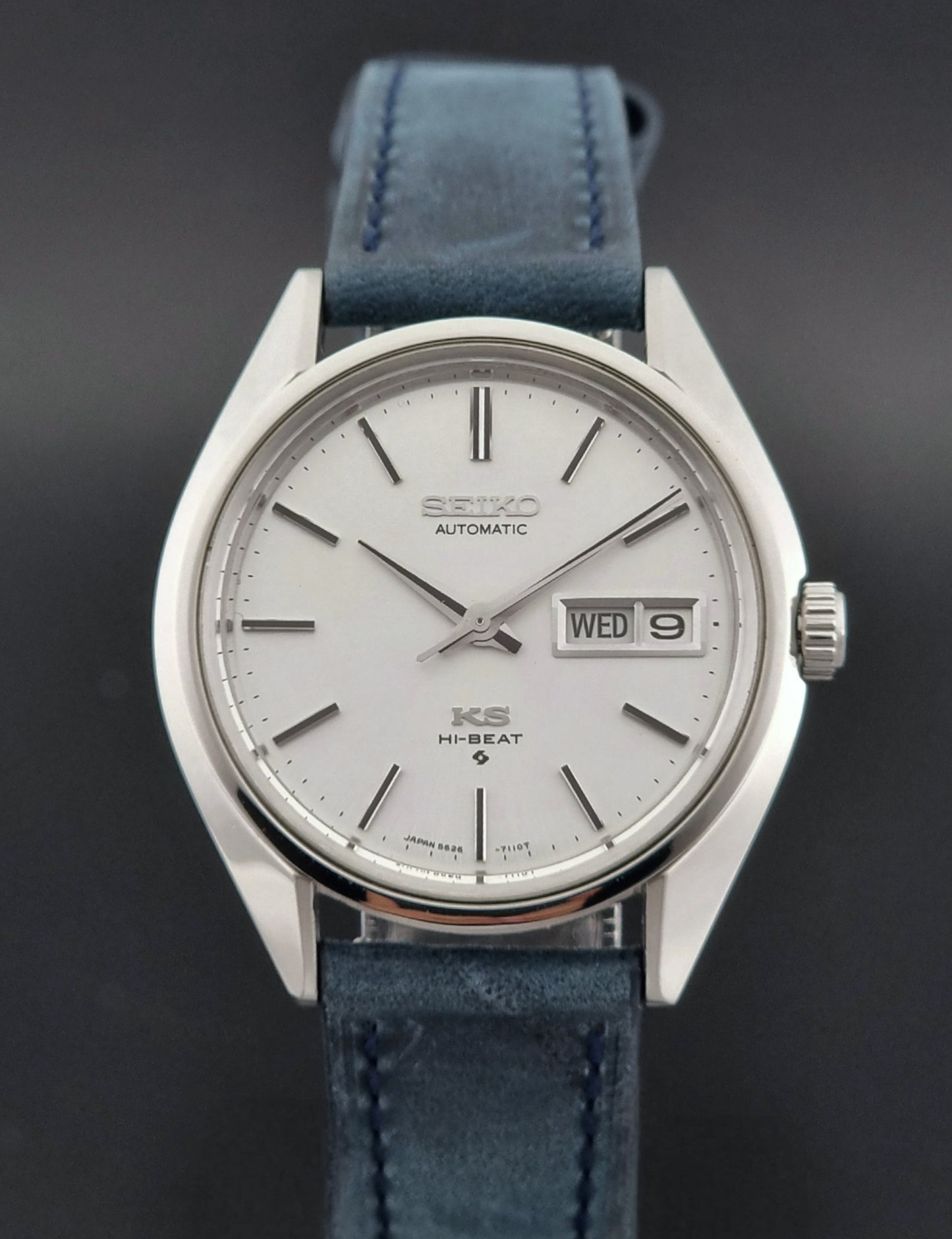Vintage King Seiko 5626-7110 Wristwatch with blue strap and silver case on a dark textured background