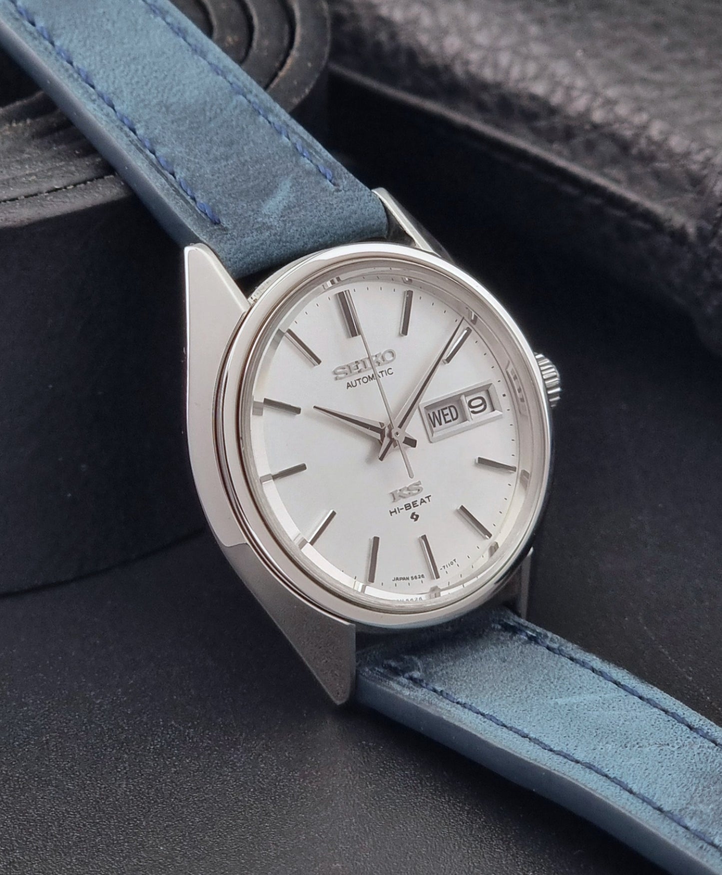 Vintage King Seiko 5626-7110 Wristwatch with blue strap and silver case on a dark textured background