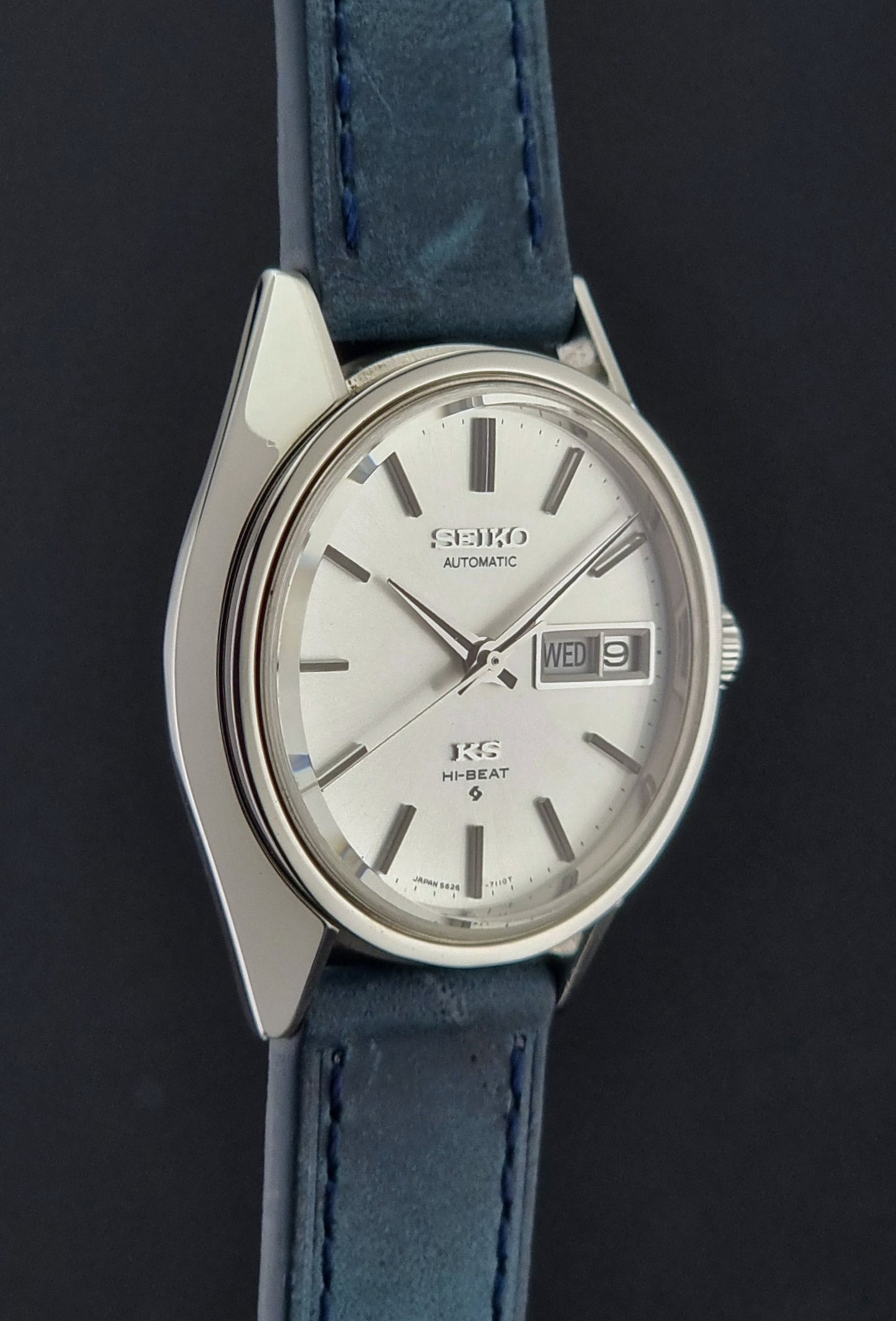 Vintage King Seiko 5626-7110 Wristwatch with blue strap and silver case on a dark textured background