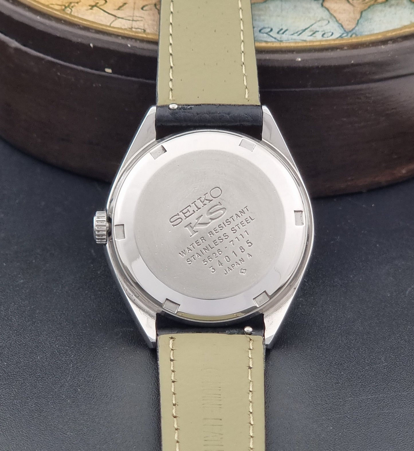 Vintage King Seiko 5626-7111 Wristwatch with a black strap on a dark background case back view