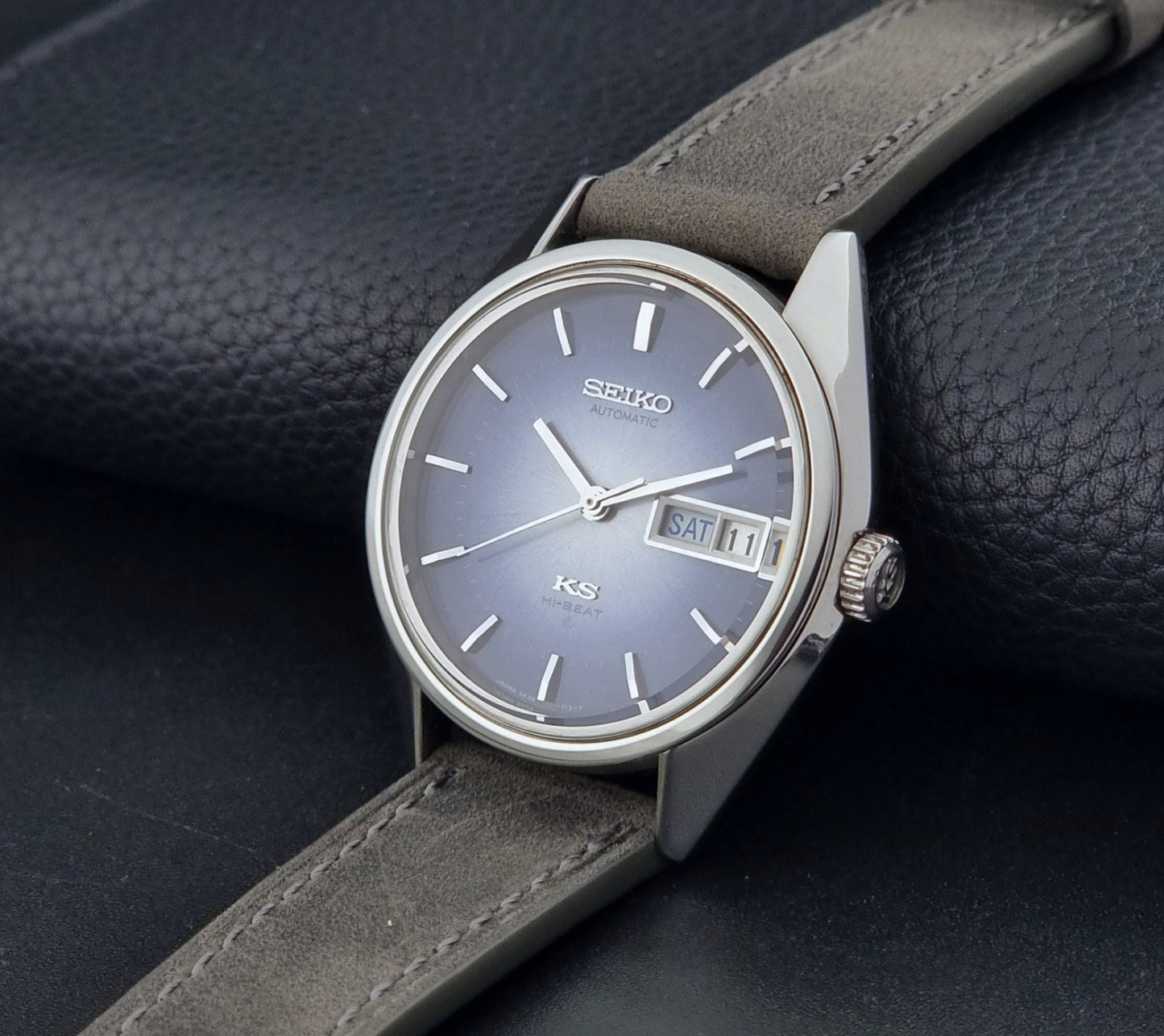 Vintage King Seiko Wristwatch 5626-7111 with a blue dial and gray leather strap on a textured dark background crown side