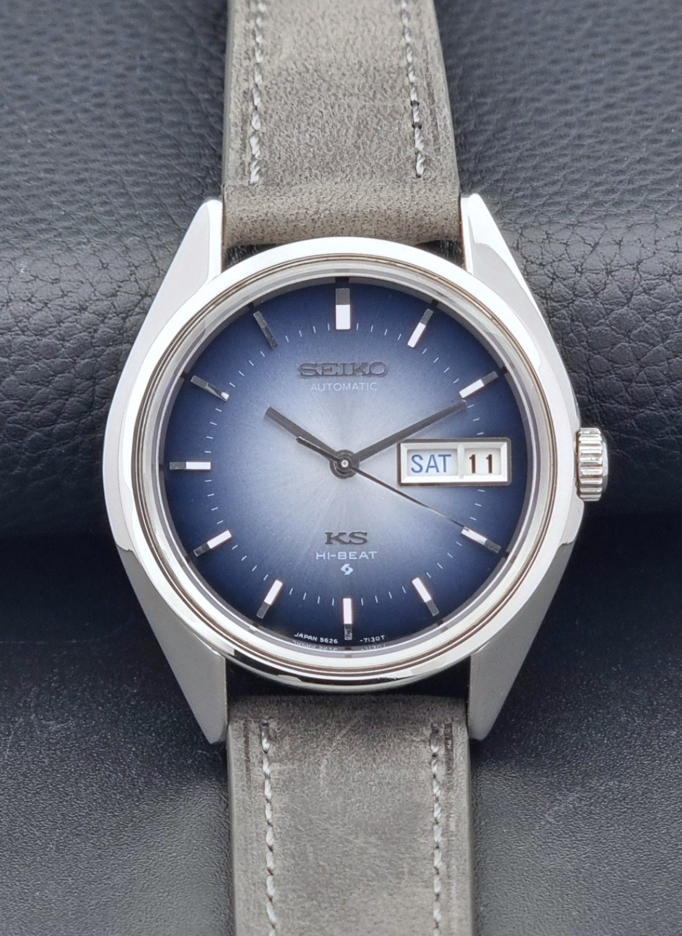 Vintage King Seiko Wristwatch 5626-7111 with a graduated blue dial and gray leather strap on a textured dark background