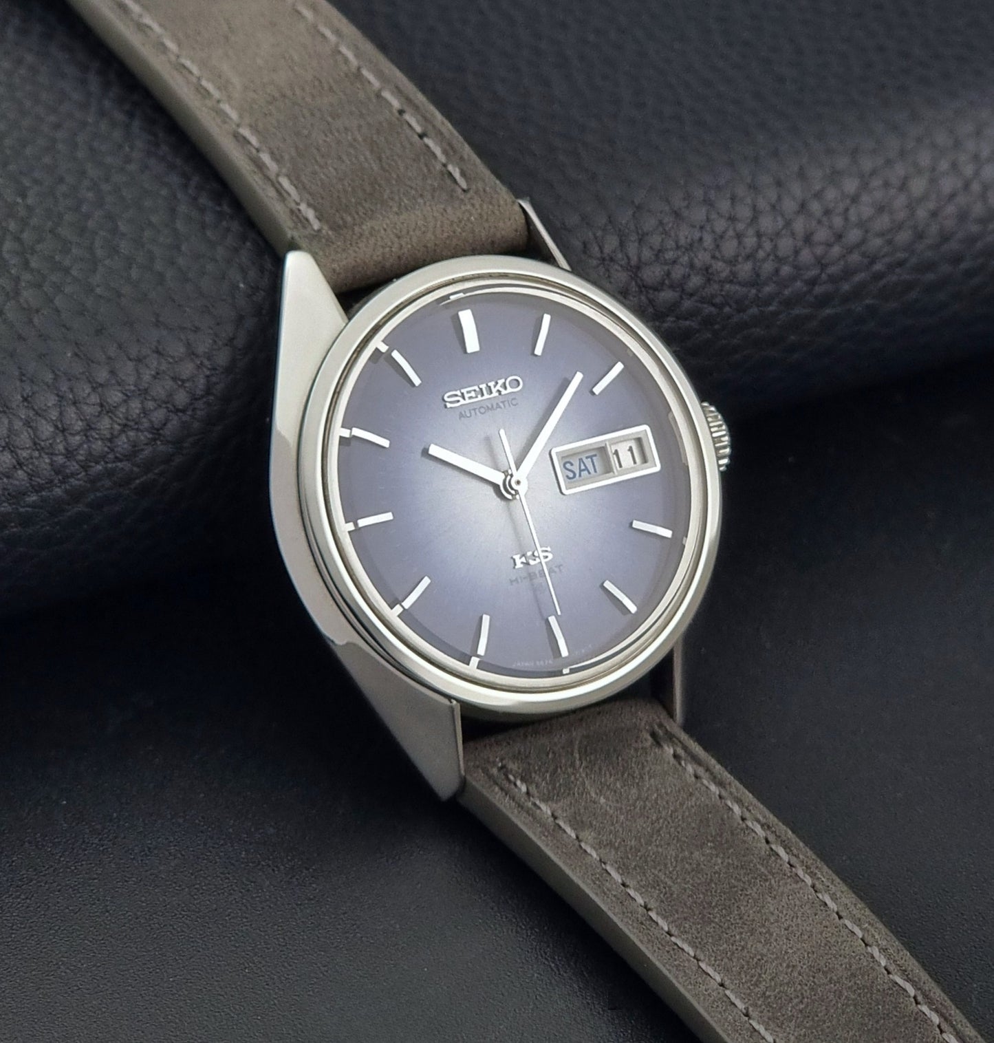 Vintage King Seiko Wristwatch 5626-7111 with a blue dial and gray leather strap on a textured dark background side