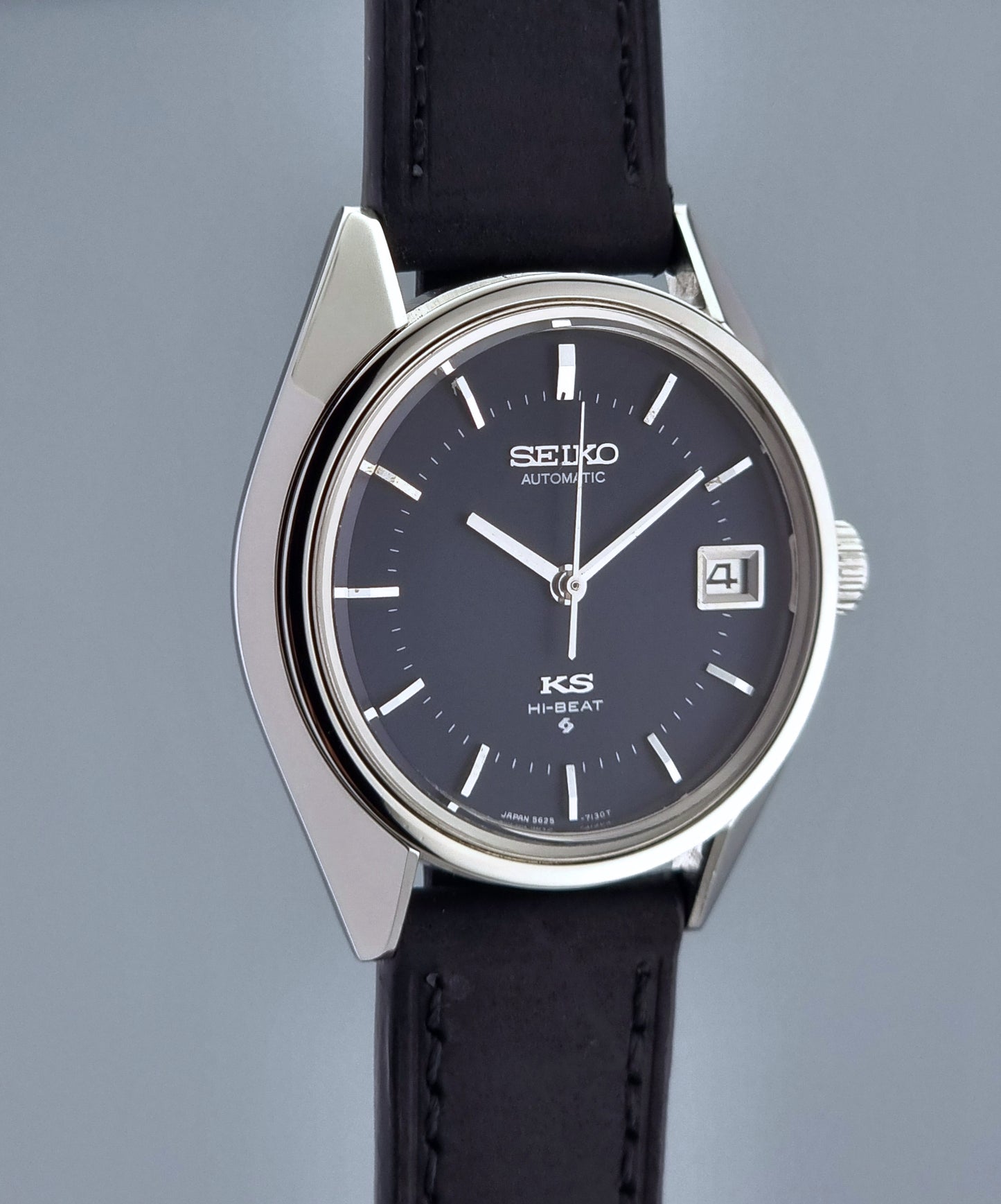 Vintage King Seiko watch with black leather strap and dark blue dial on a gray background