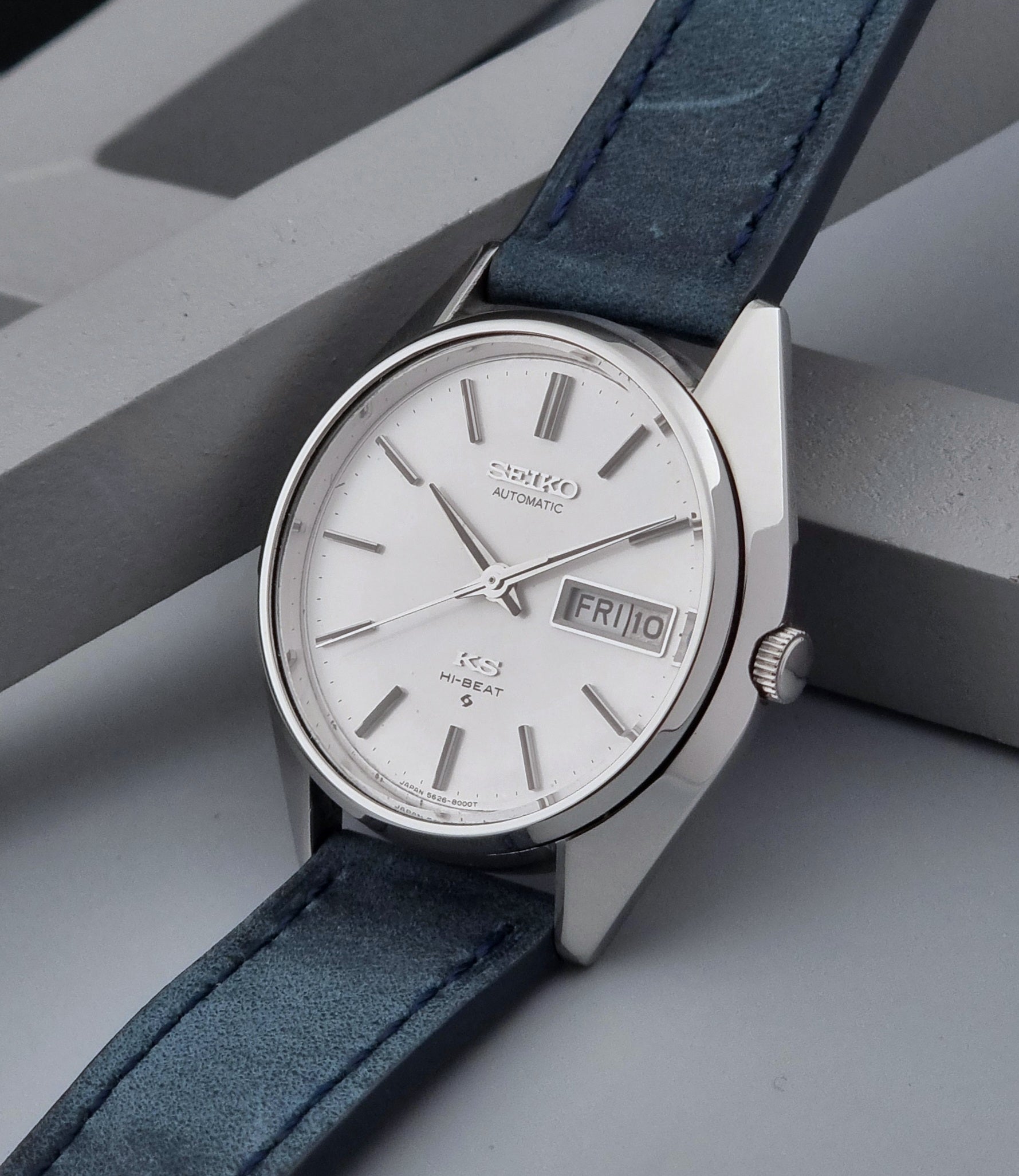 Vintage King Seiko Wristwatch 5626-8000 with a blue leather strap on a grey background crown side
