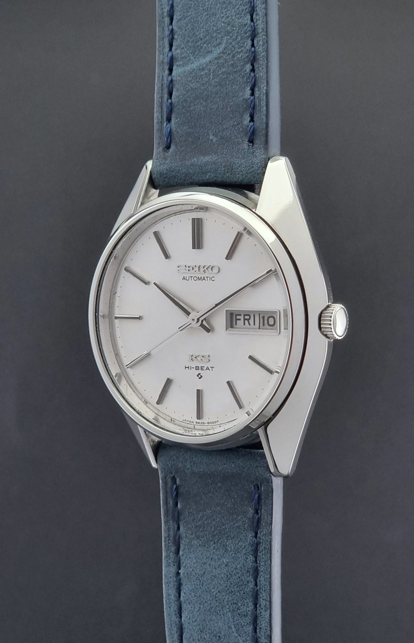 Vintage King Seiko Wristwatch 5626-8000 with a blue leather strap on a grey background crown side profile