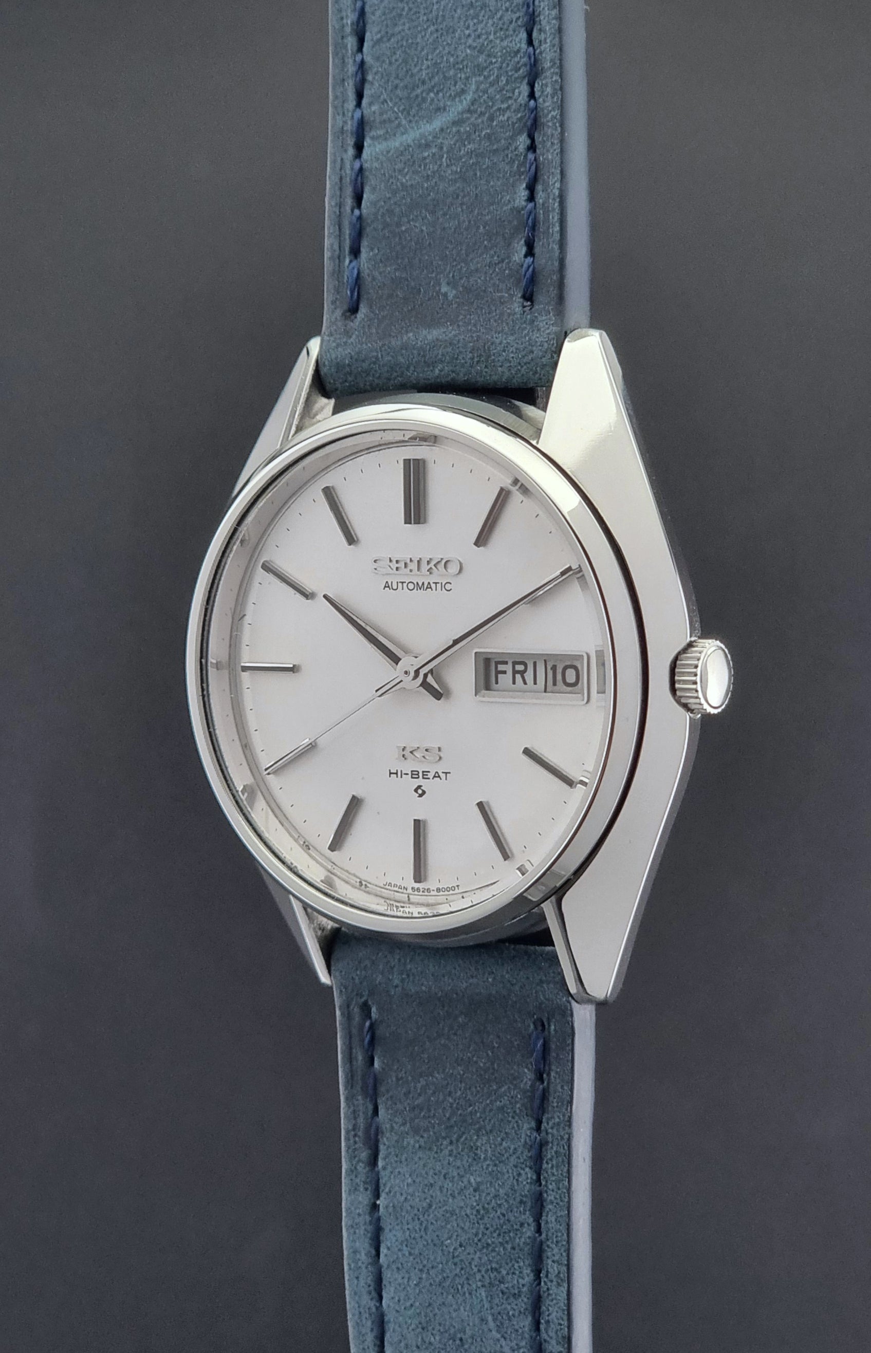 Vintage King Seiko Wristwatch 5626-8000 with a blue leather strap on a grey background crown side profile