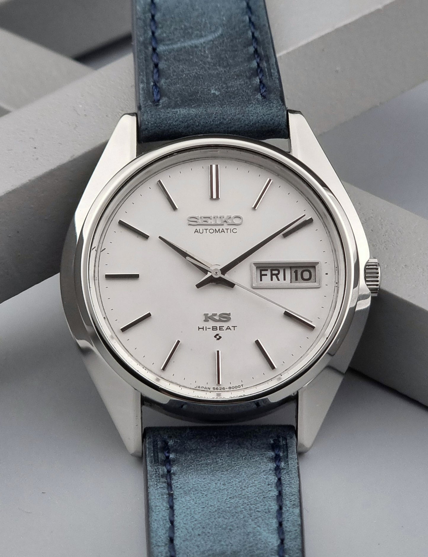 Vintage King Seiko Wristwatch 5626-8000 with a blue leather strap on a grey background front close up