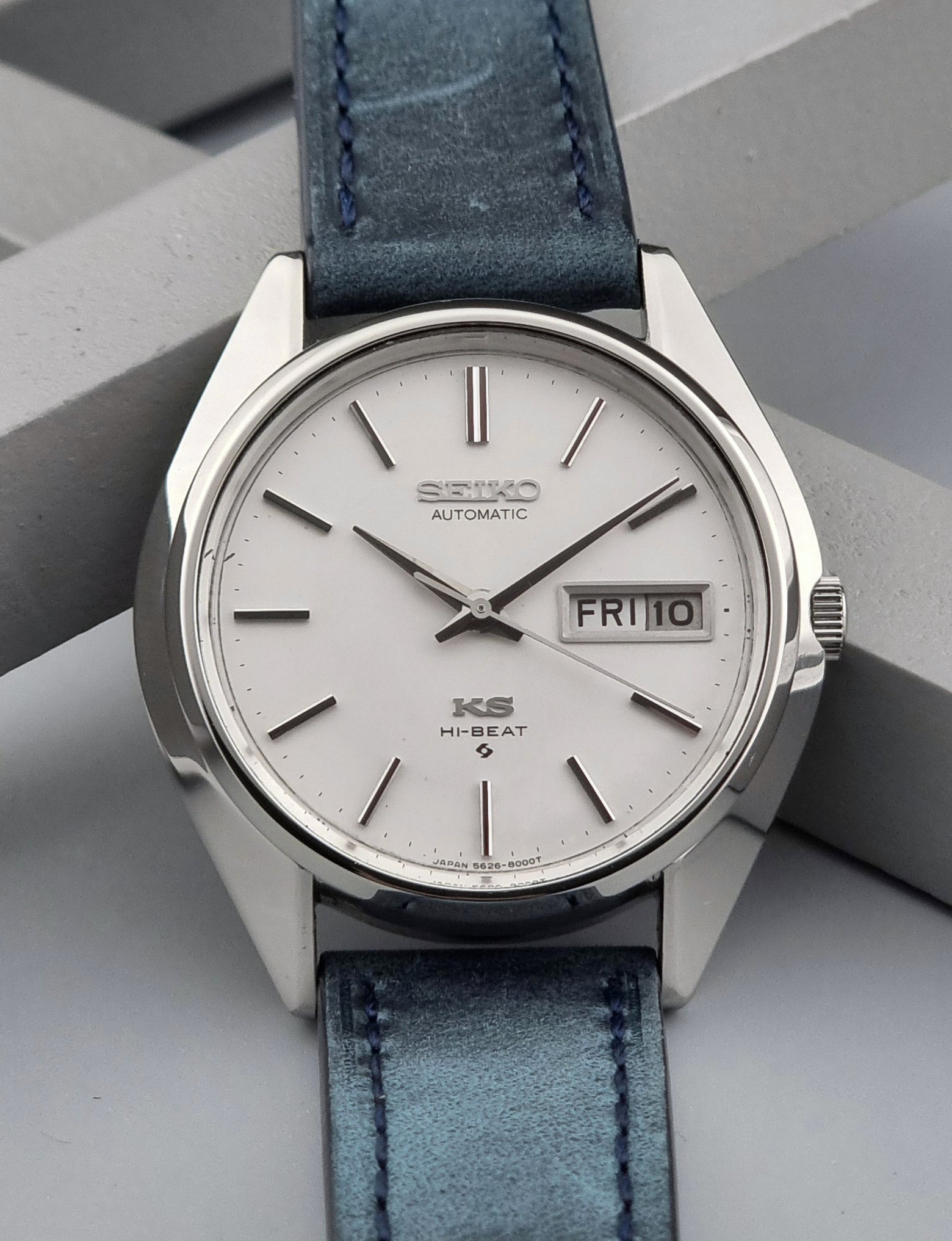 Vintage King Seiko Wristwatch 5626-8000 with a blue leather strap on a grey background front close up