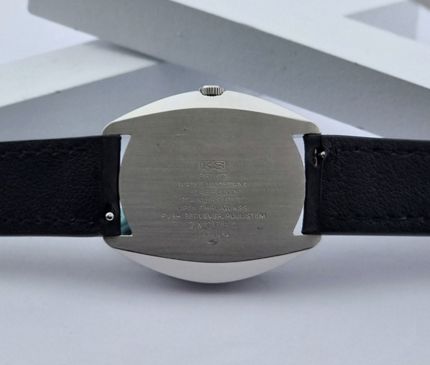 Vintage King Seiko Watch Special 5246-6000 with black leather strap on a light gray background case abck view