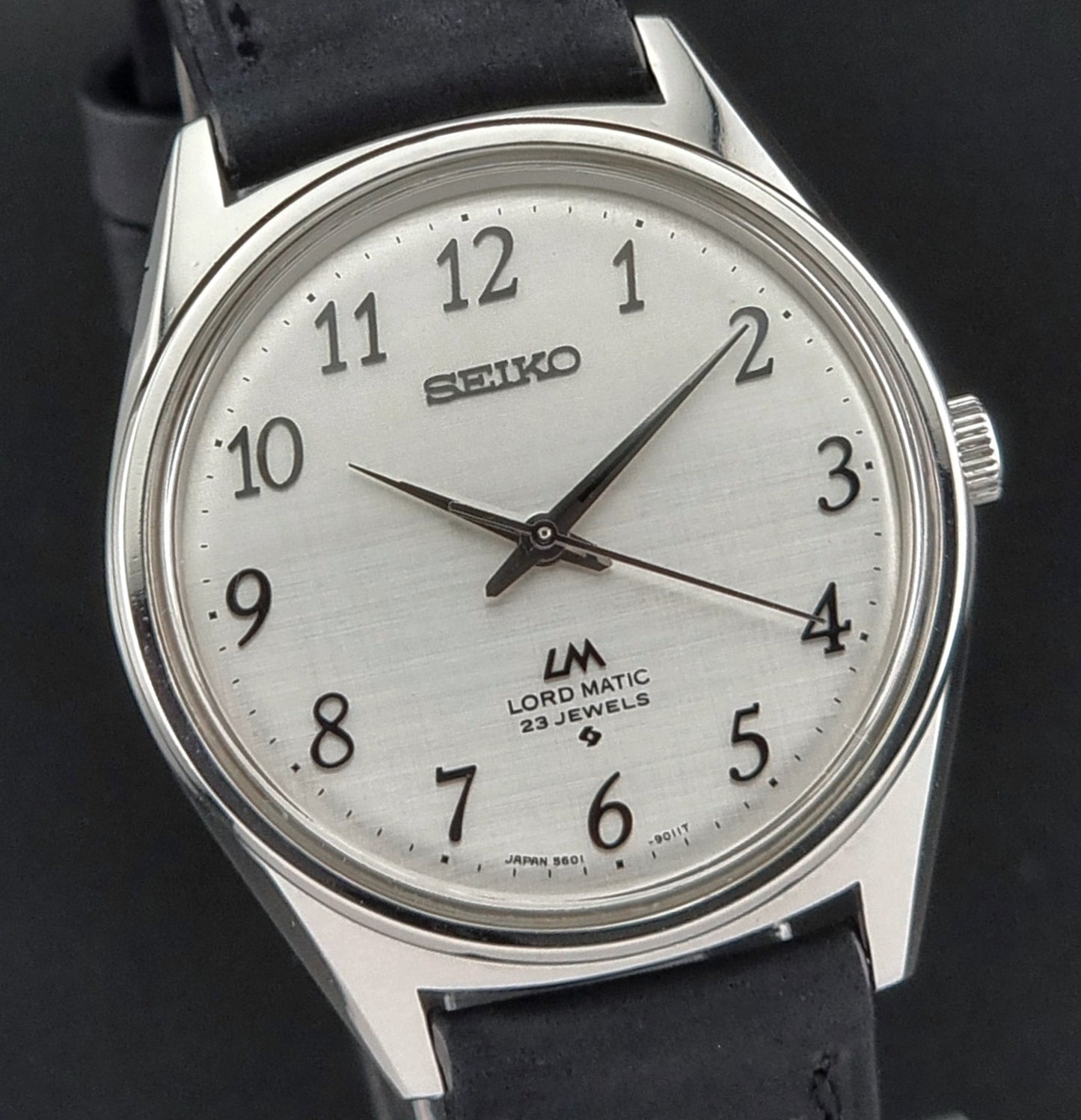 Seiko watch with black leather strap on a dark background