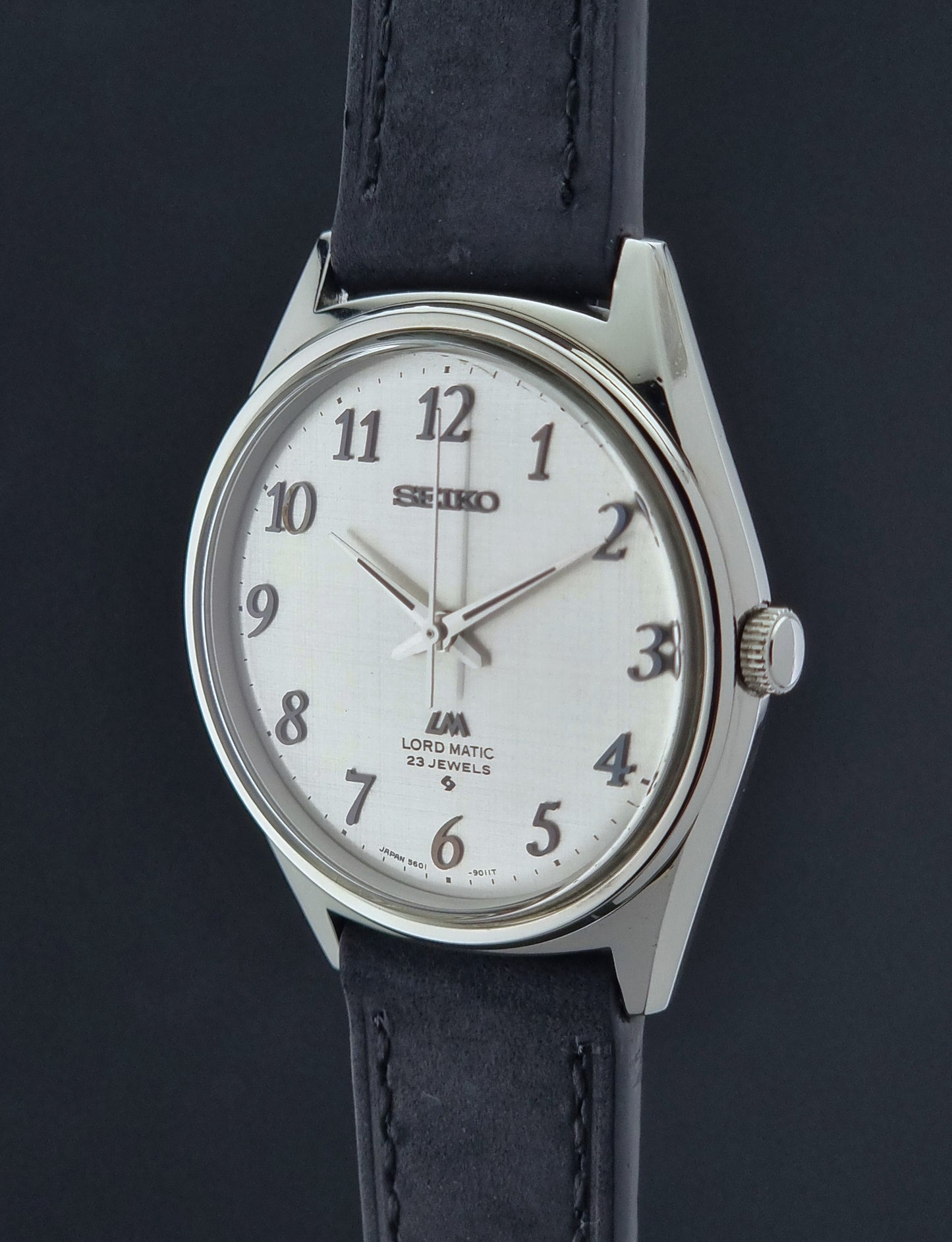 Seiko watch with black leather strap on a dark background