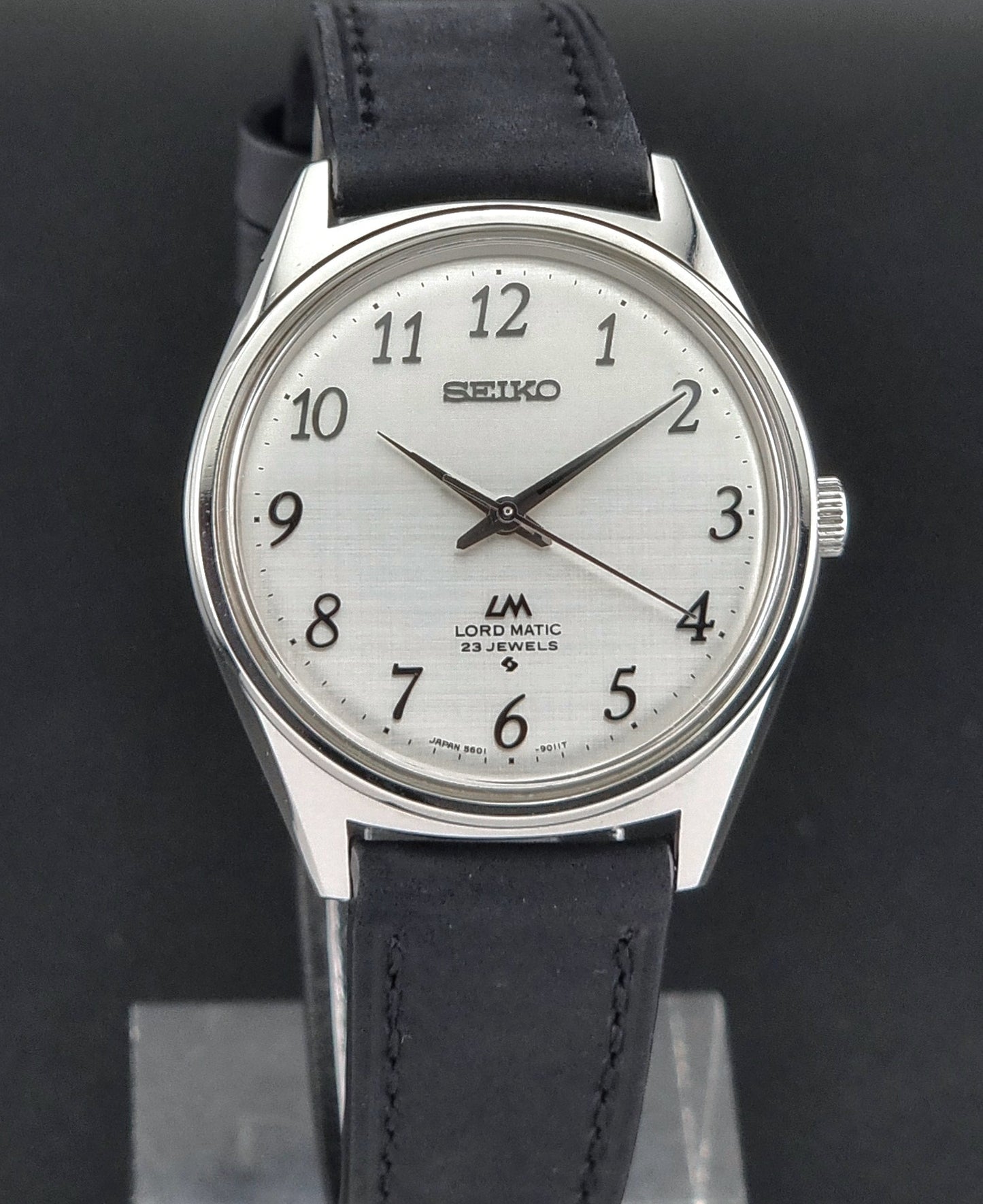 Seiko watch with black leather strap on a dark background