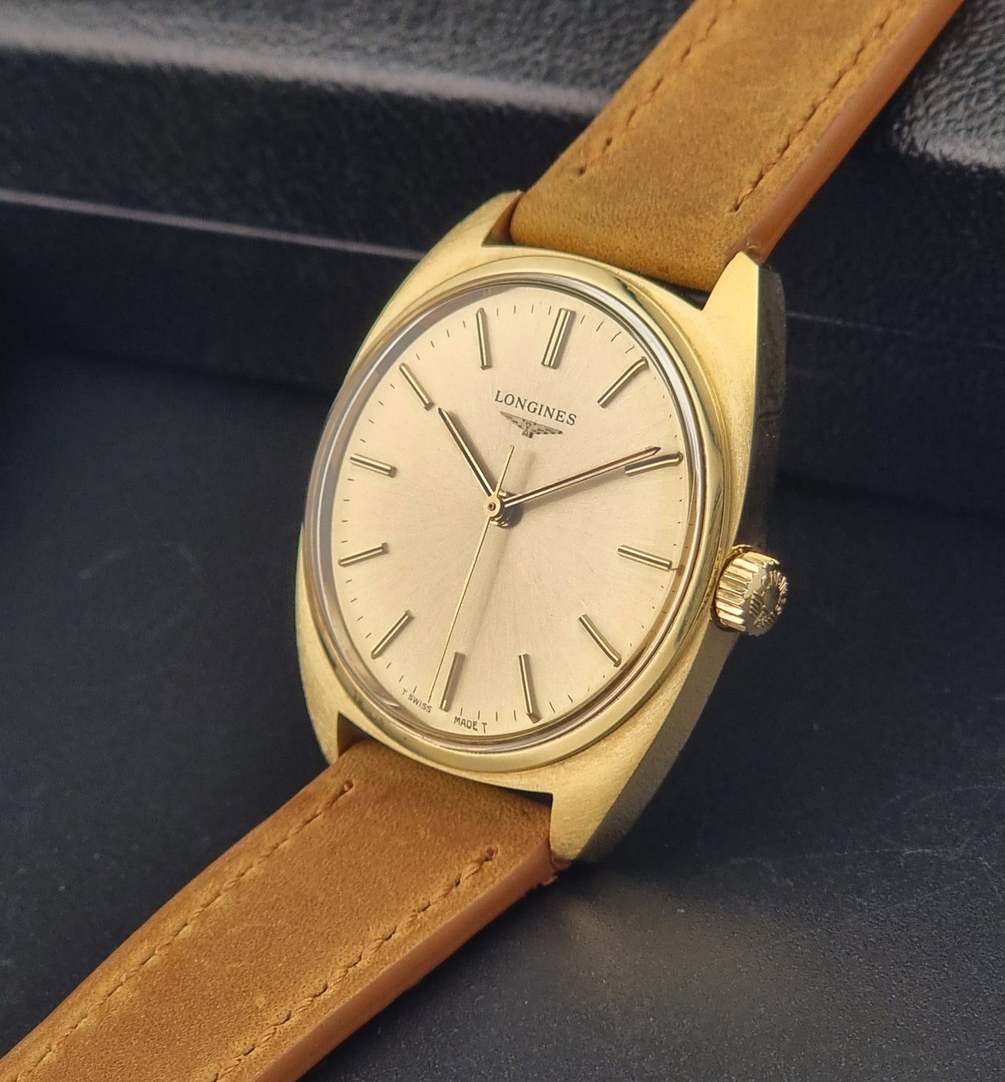 Vintage Gold Longines watch with brown leather strap on a dark background