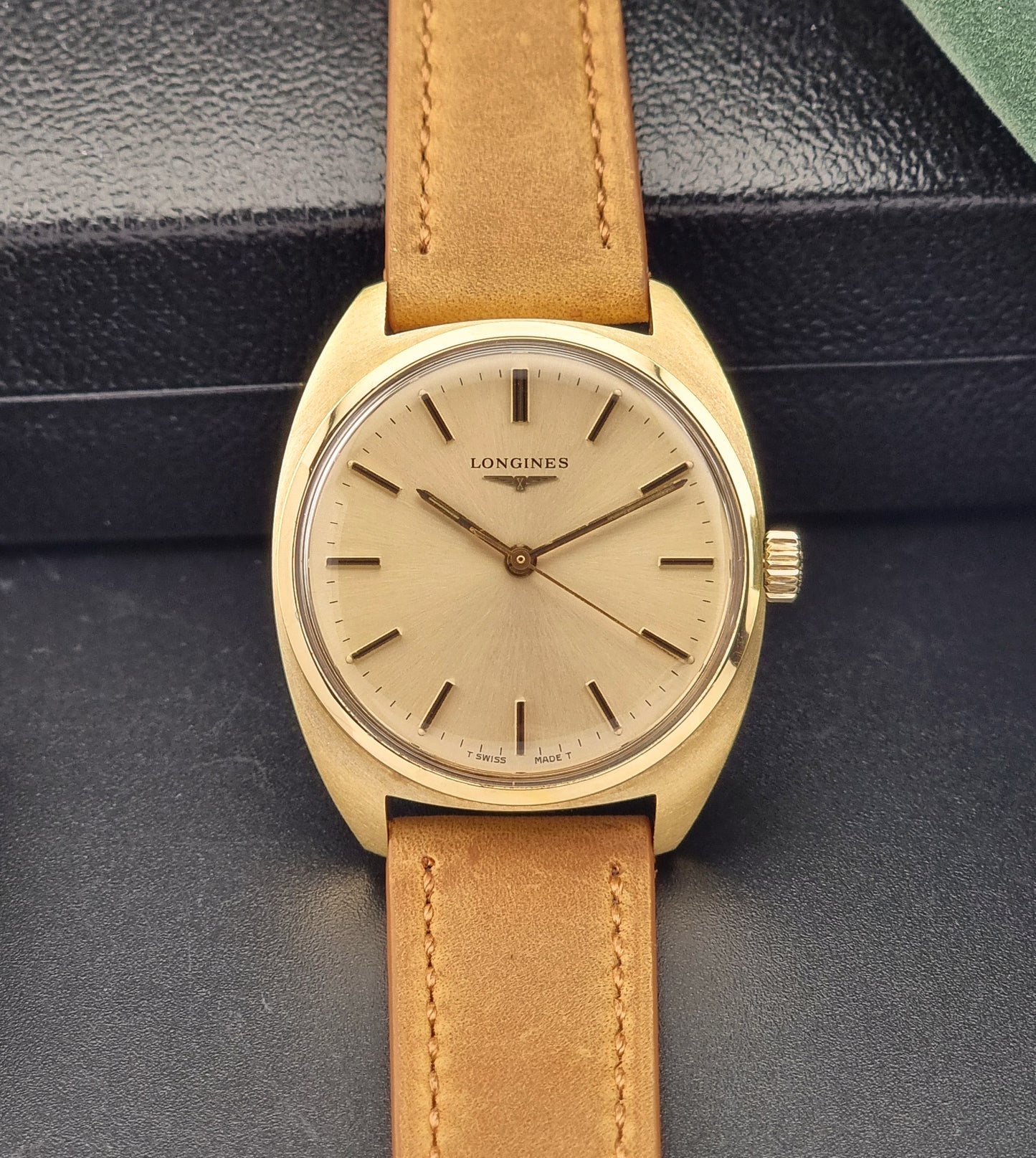 Vintage Gold Longines watch with brown leather strap on a dark background